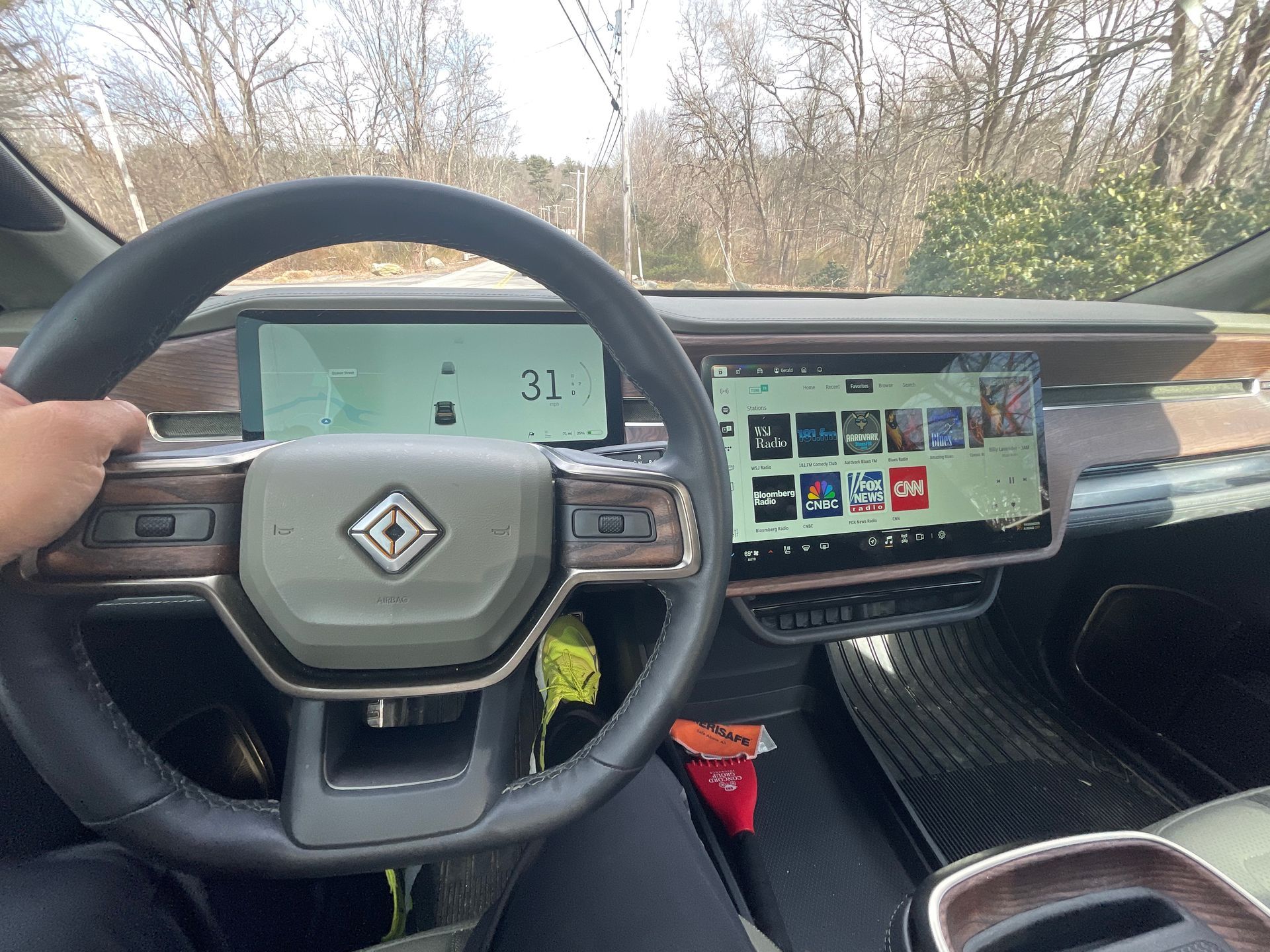 A person is sitting in the driver 's seat of an electric car.