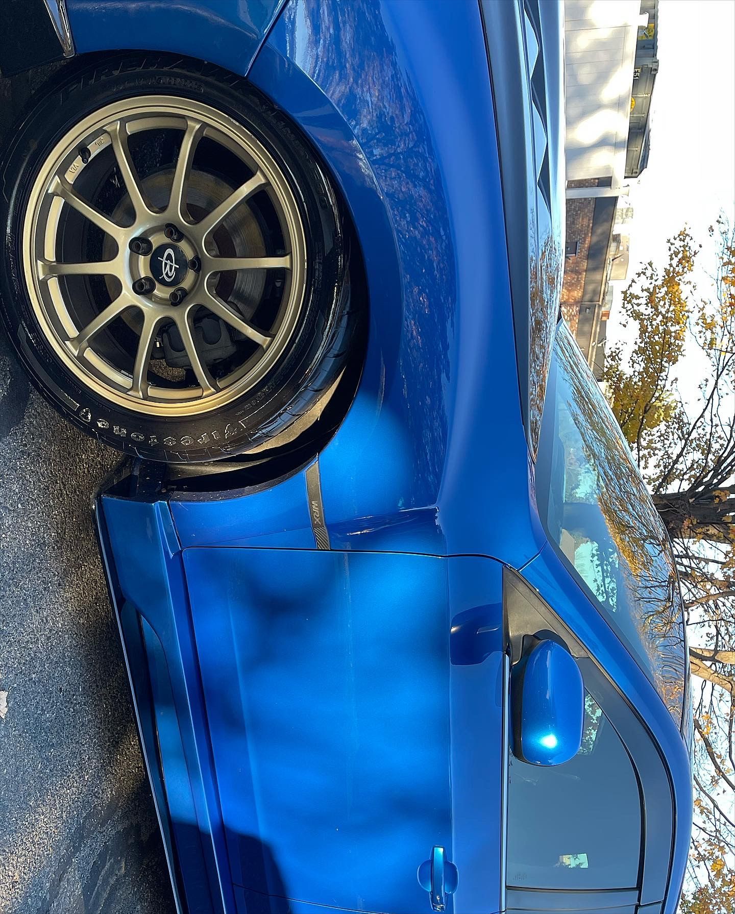 A blue car is parked on the side of the road