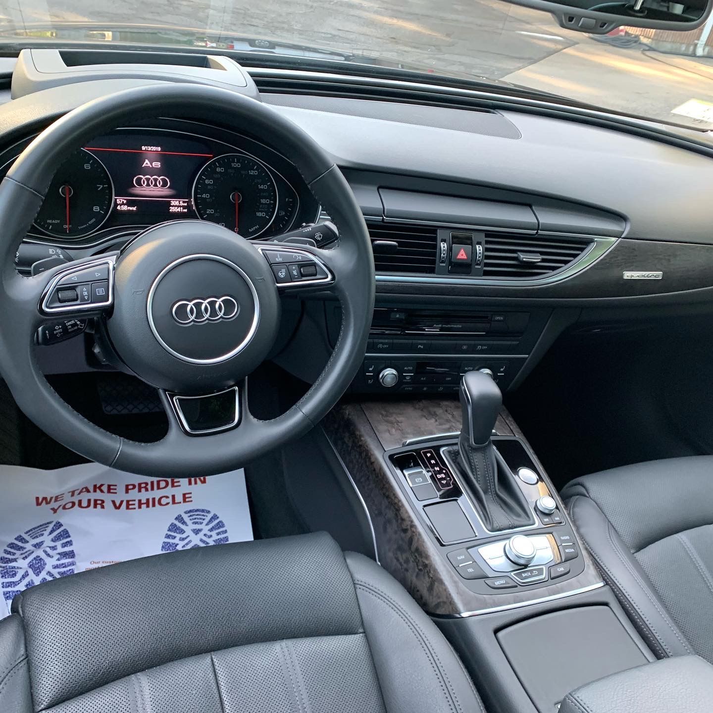 The interior of a car with a steering wheel and dashboard