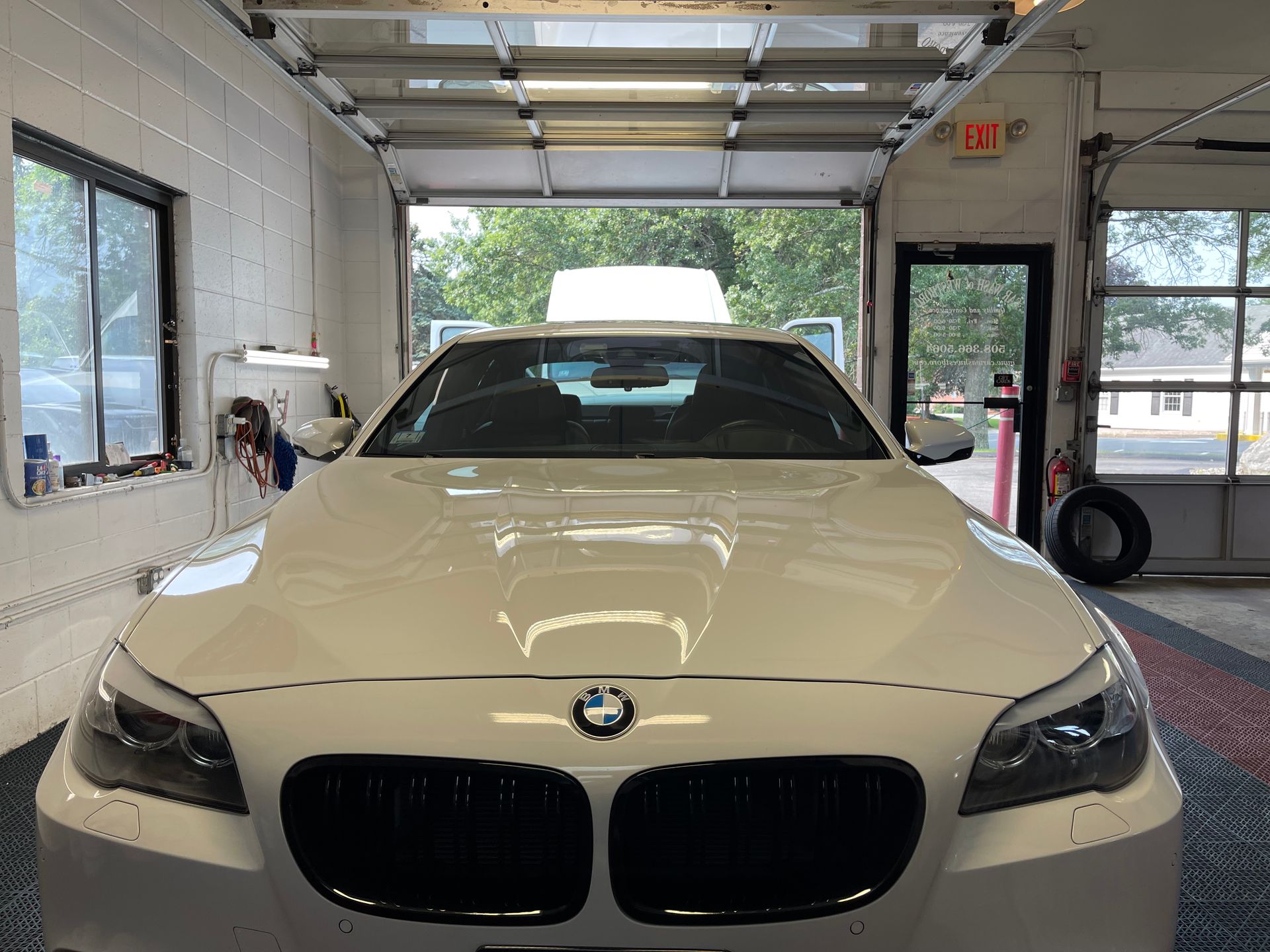 A white bmw is parked in a garage.