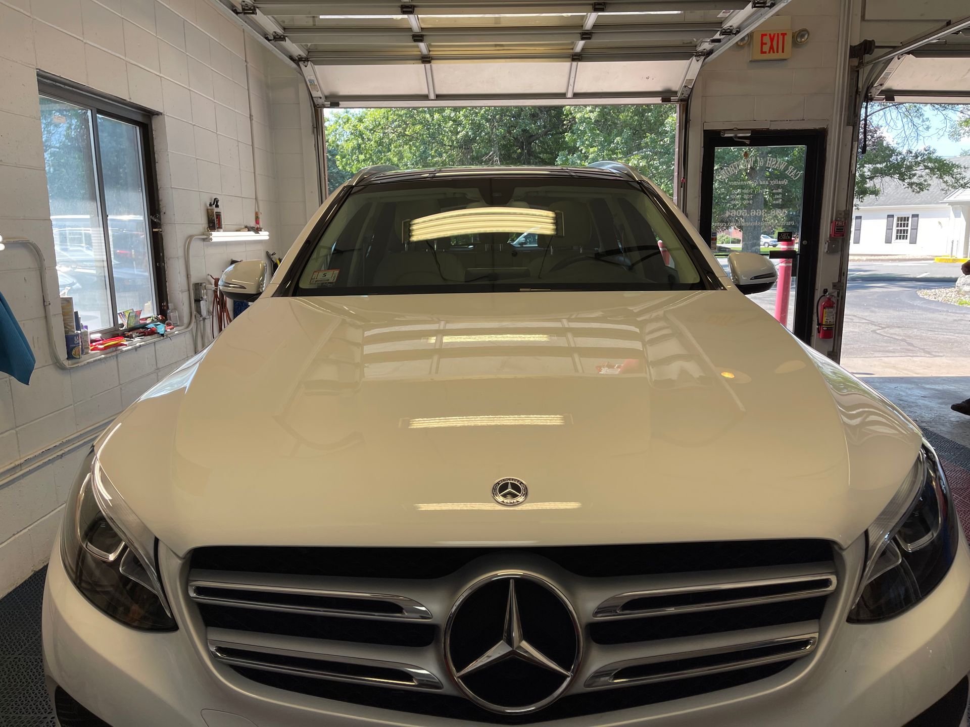 A white mercedes benz is parked in a garage.