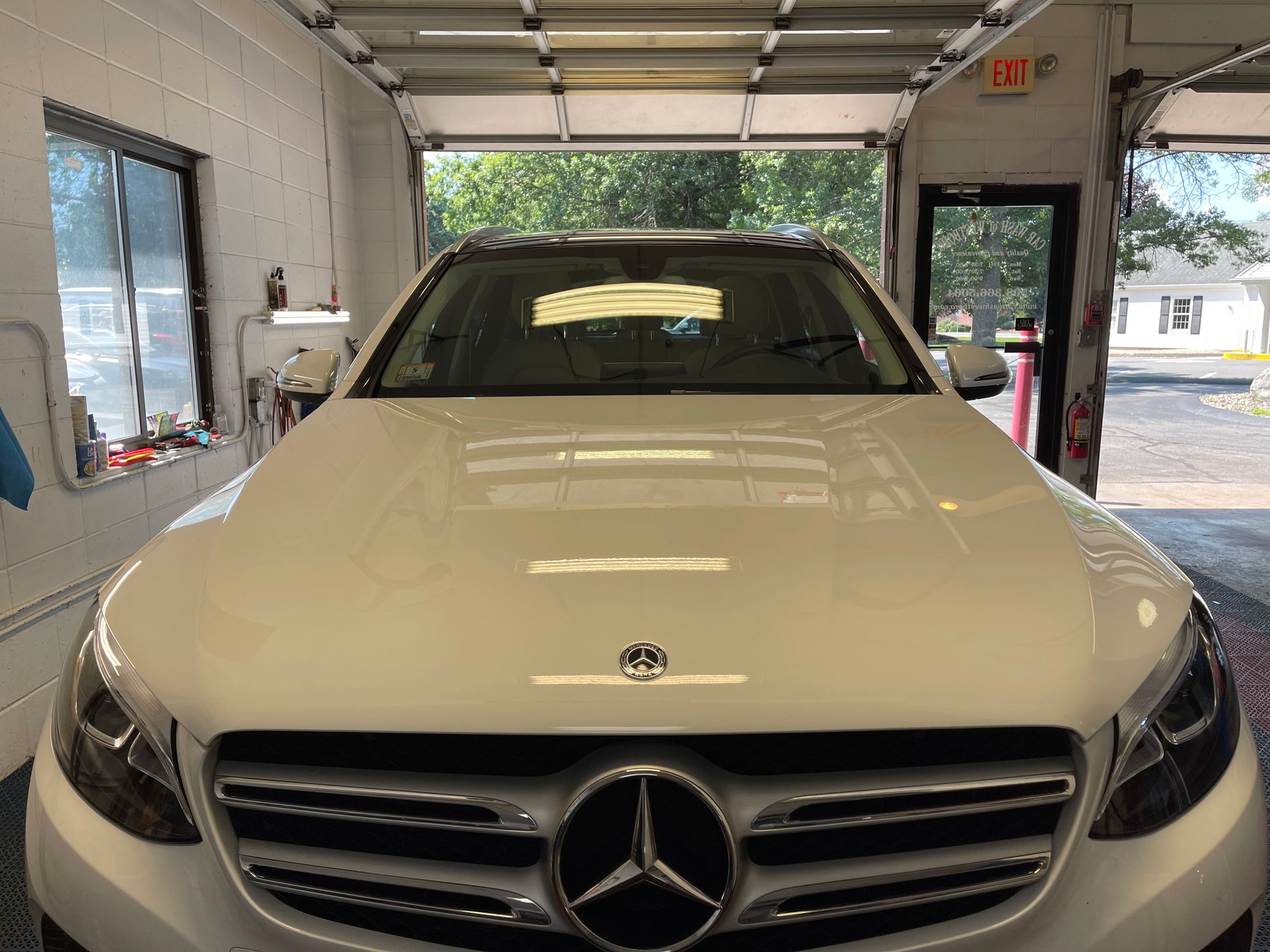 A white mercedes benz is parked in a garage.