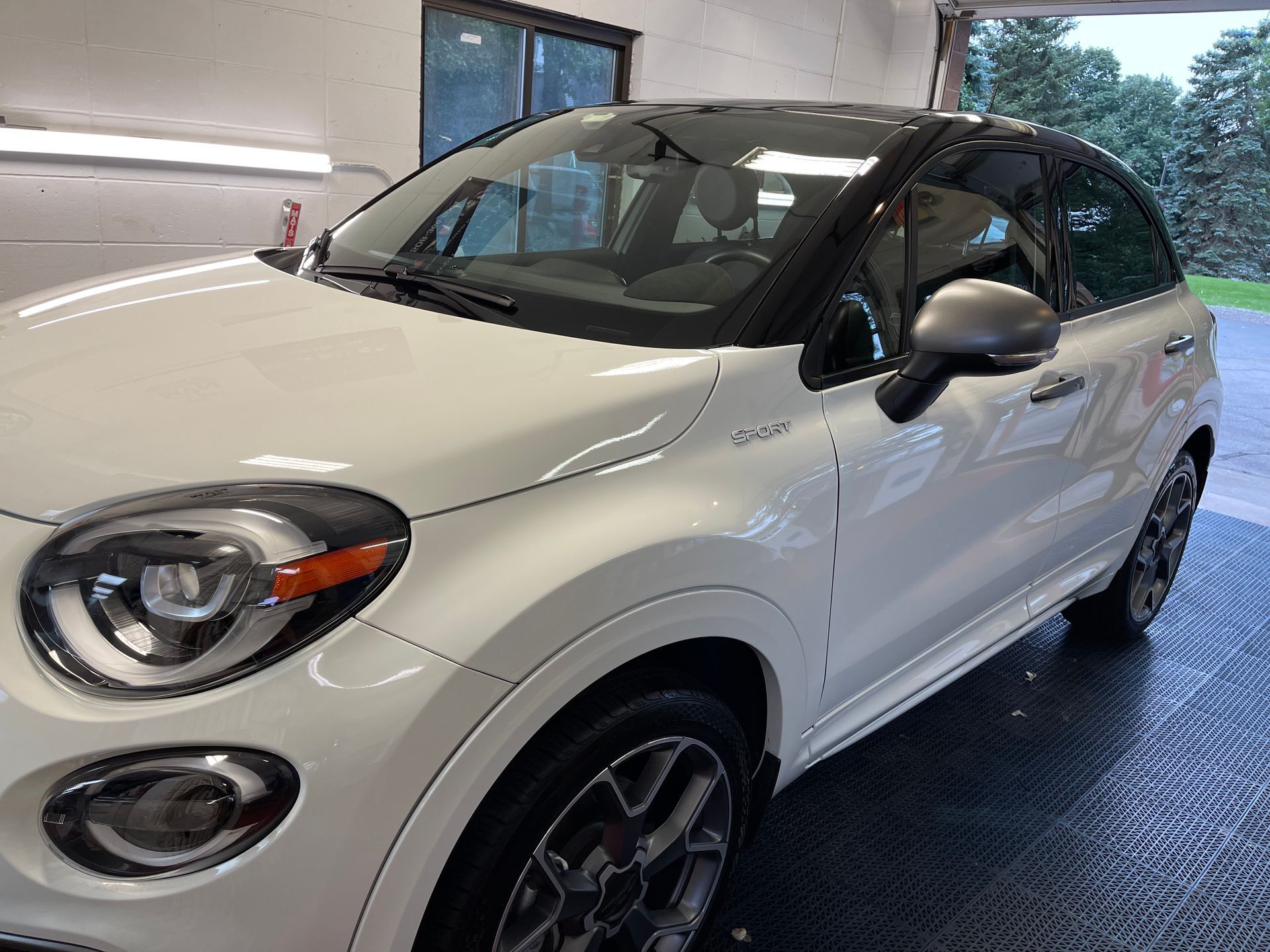 A white car is parked in a garage.