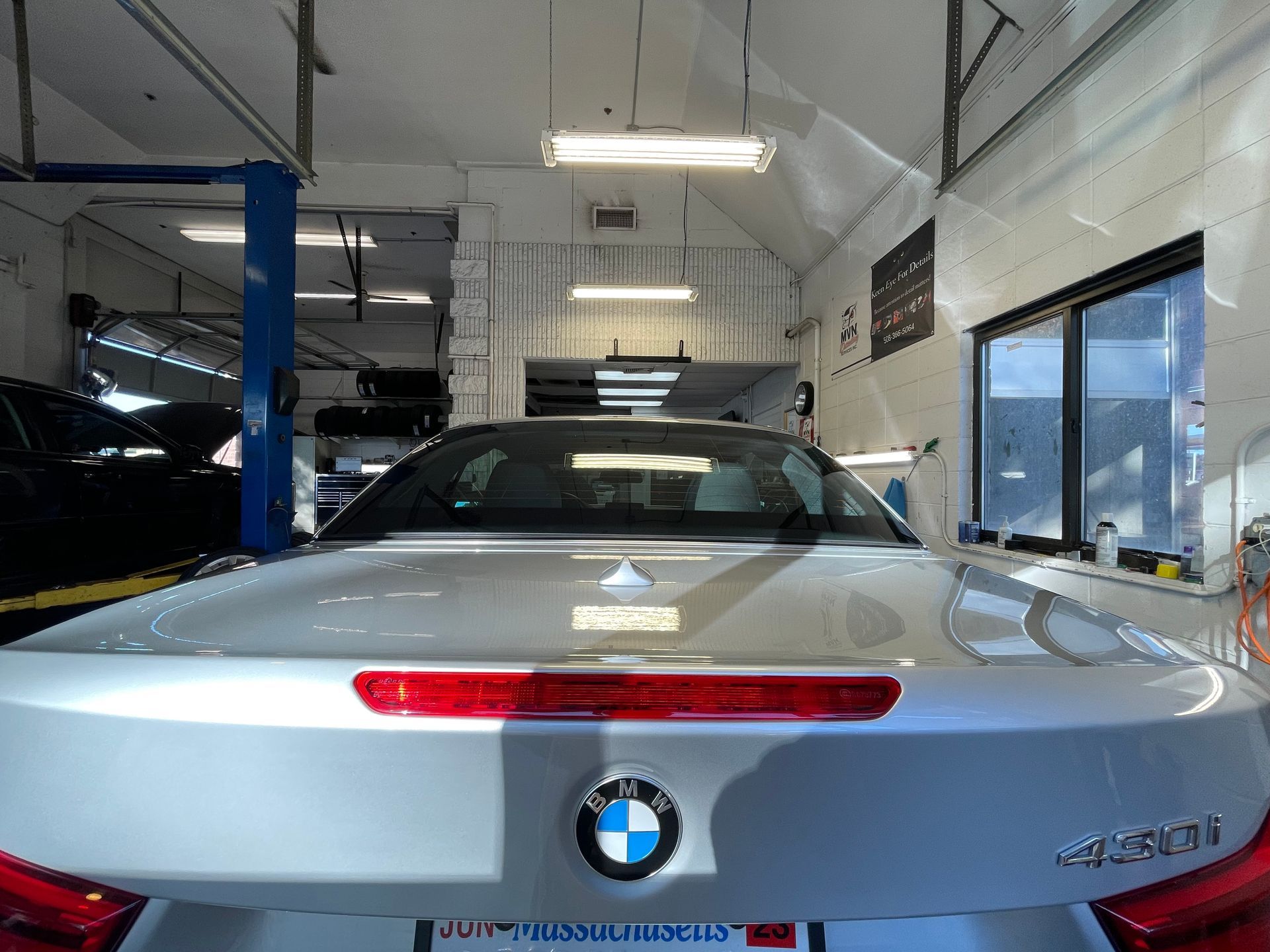 A silver bmw is parked in a garage