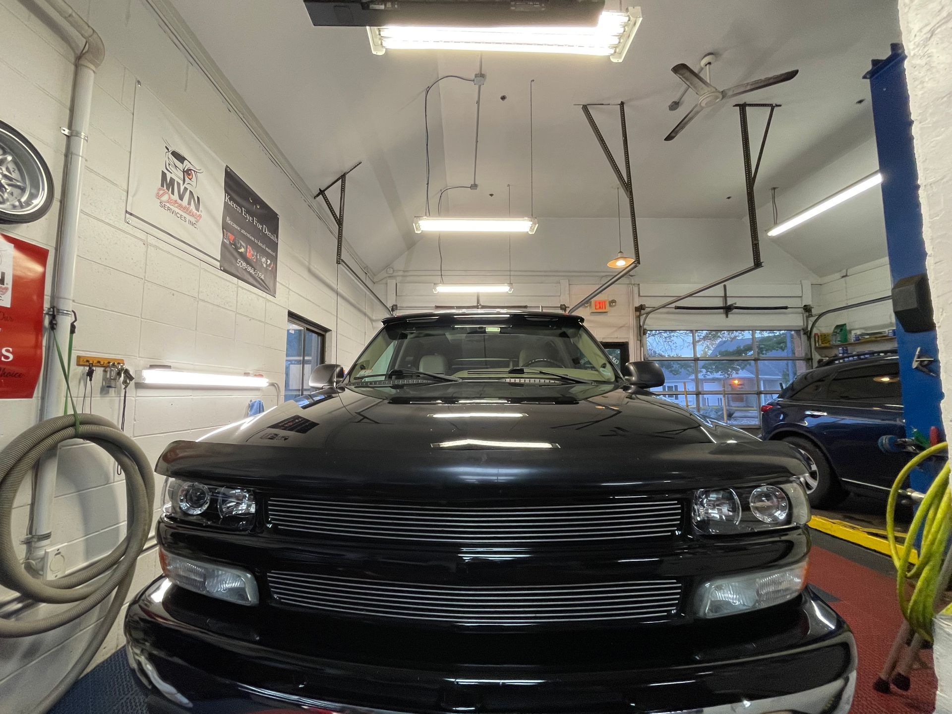 A black truck is parked in a garage.
