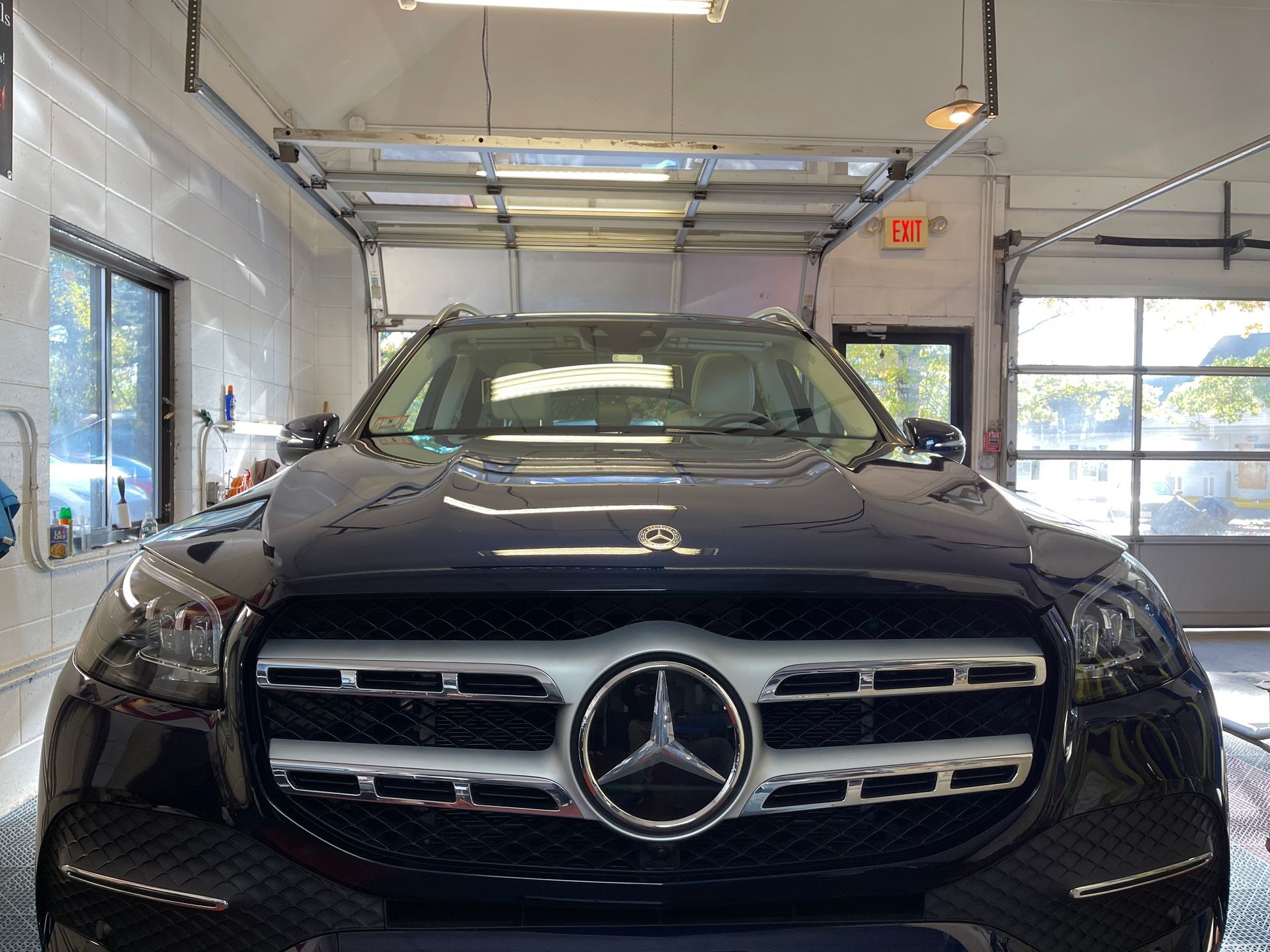 A black mercedes benz is parked in a garage.