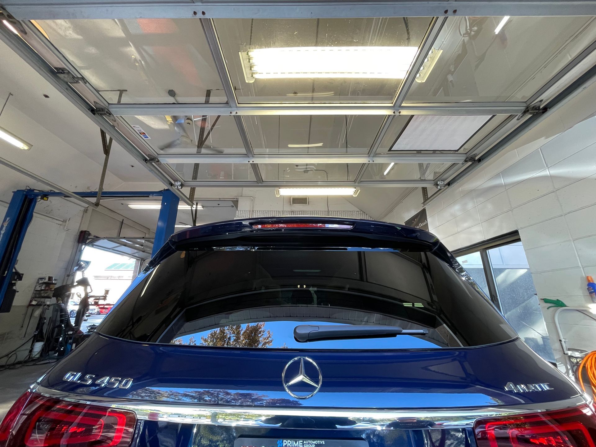 A blue mercedes benz is parked in a garage.