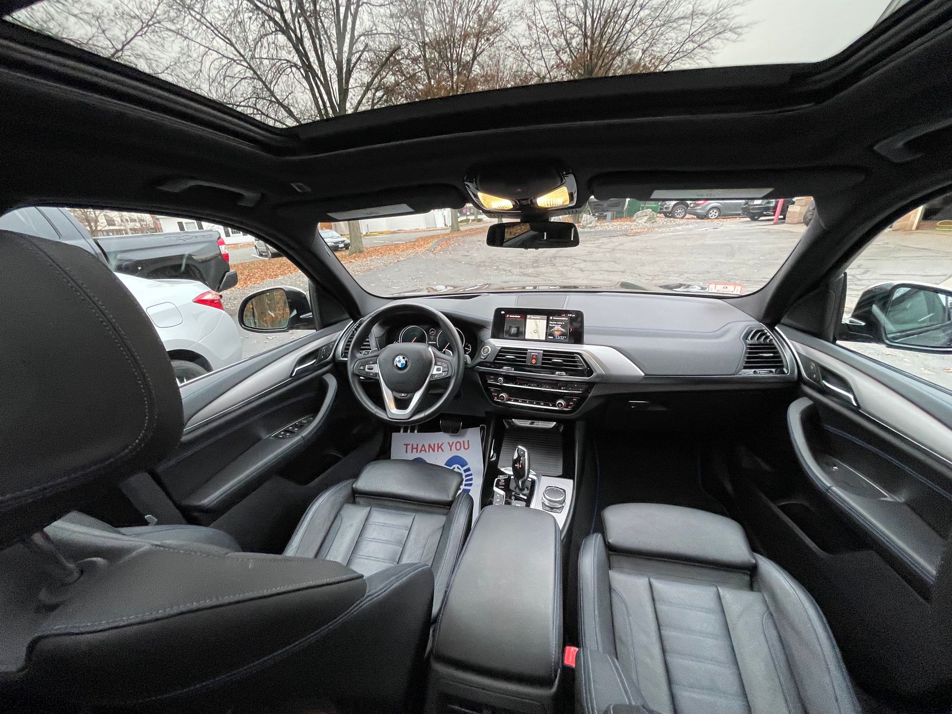 The inside of a car with a sunroof and leather seats.