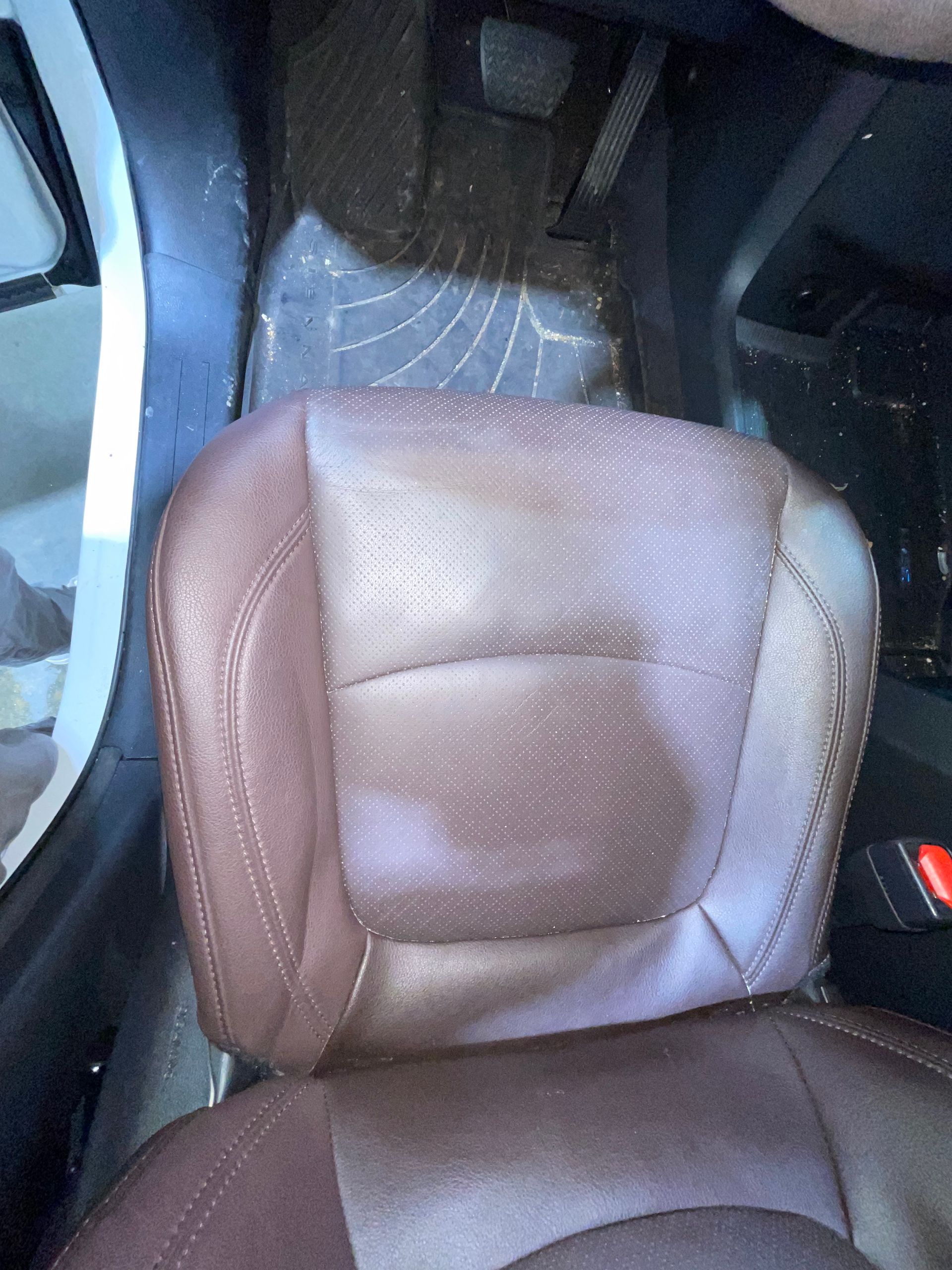 A close up of a brown leather car seat