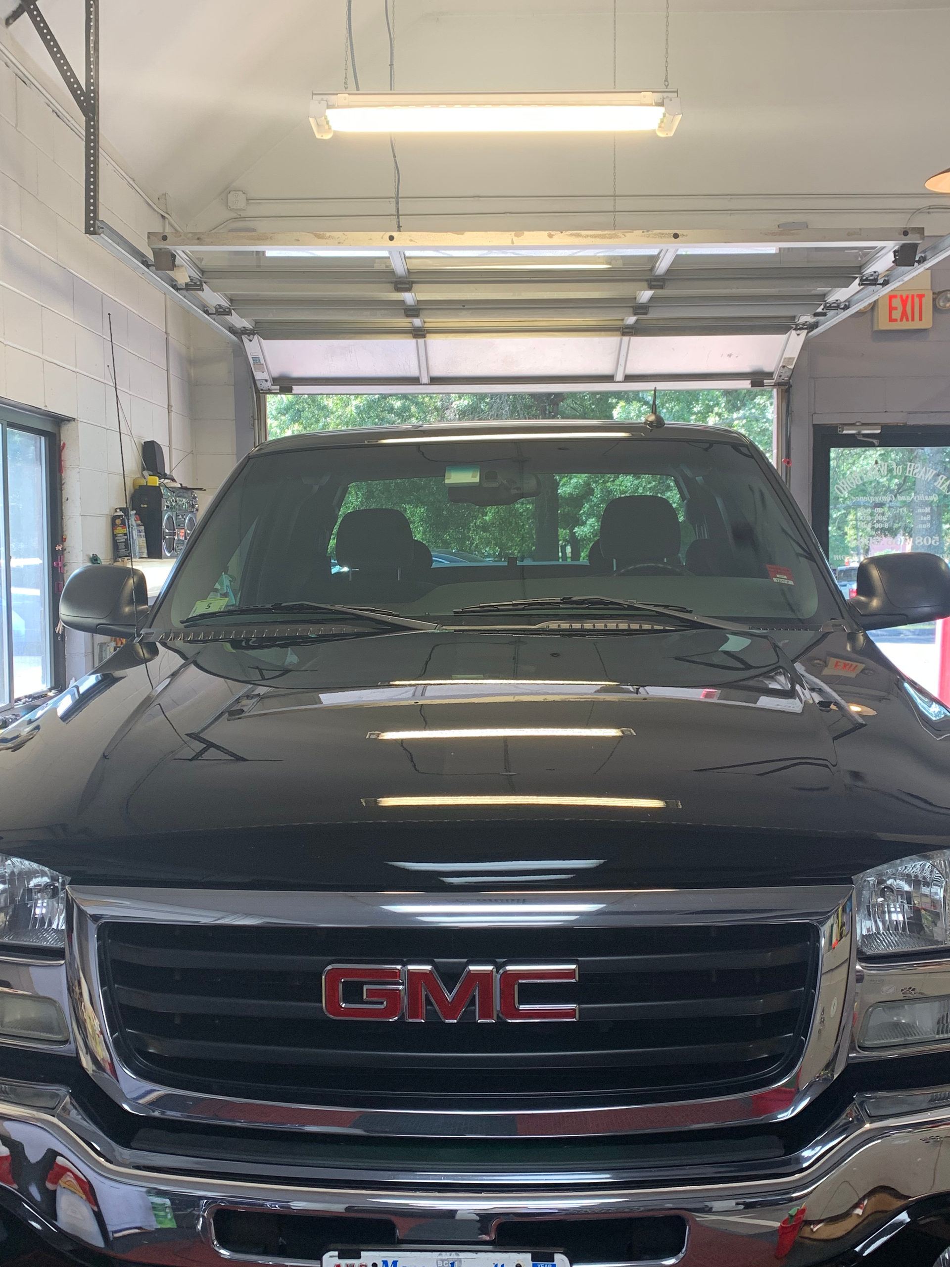 A black gmc truck is parked in a garage