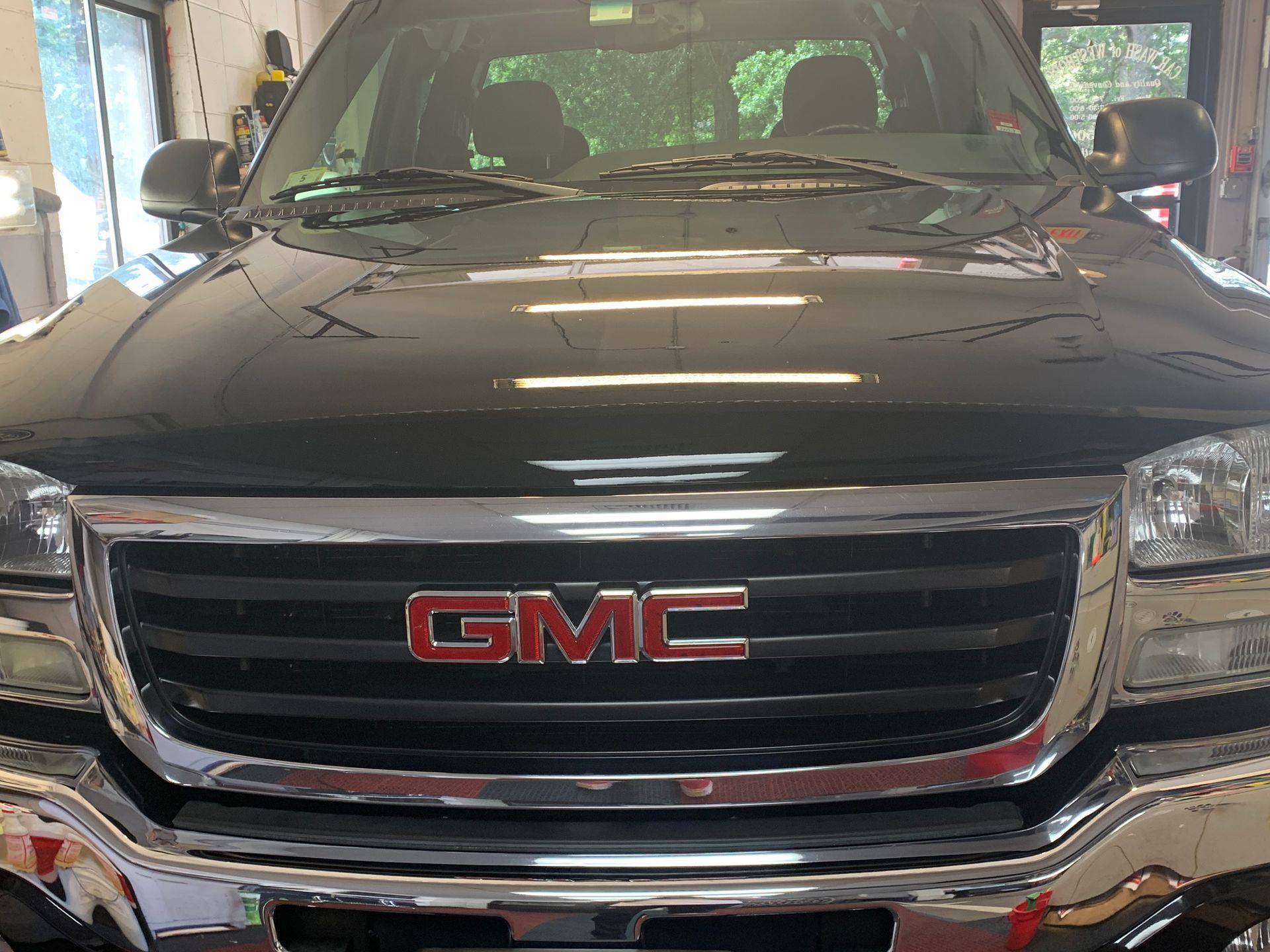 A black gmc truck is parked in a garage.