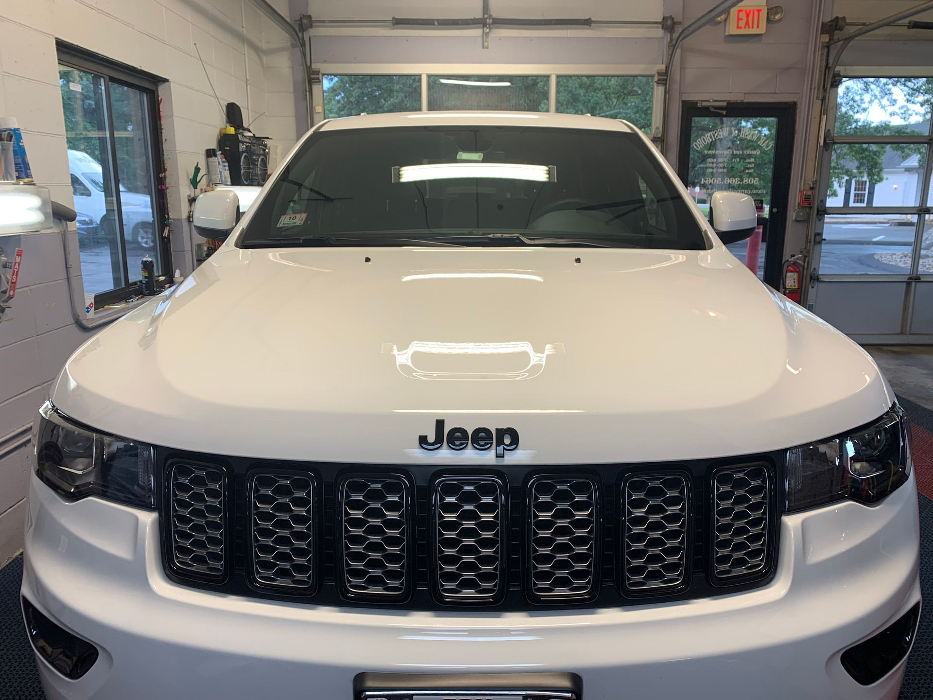 A white jeep grand cherokee is parked in a garage.