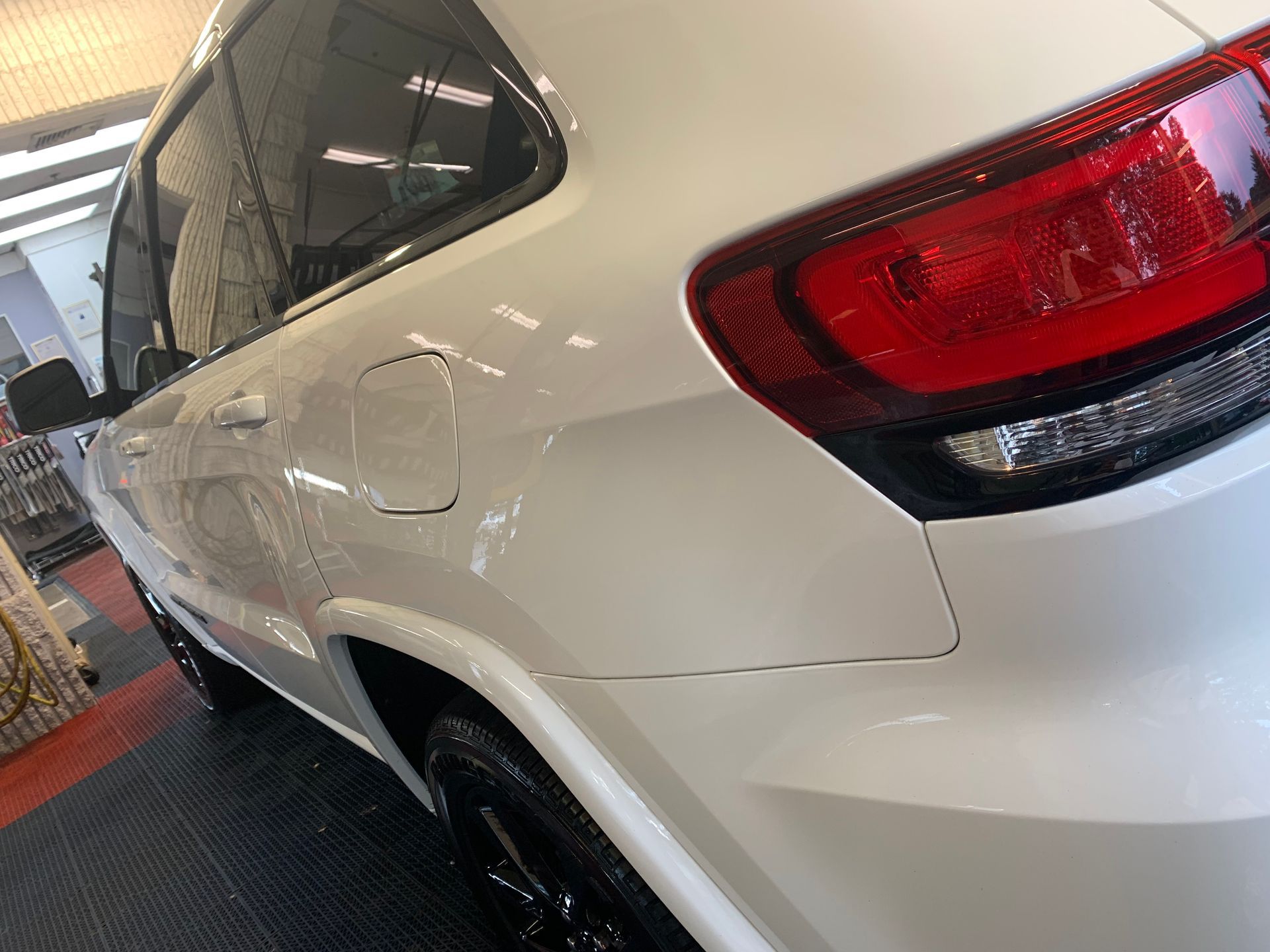 A white jeep grand cherokee is parked in a garage.