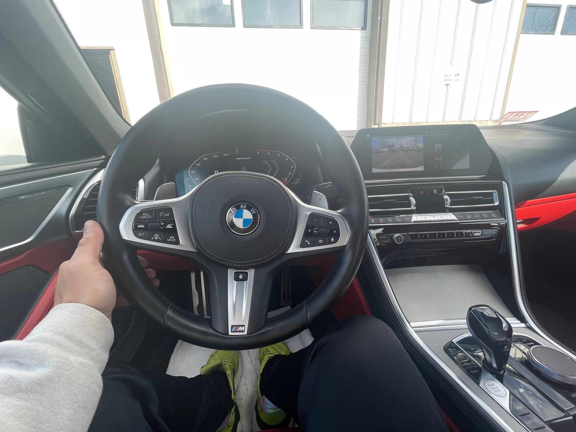A person is sitting in a bmw and holding the steering wheel.