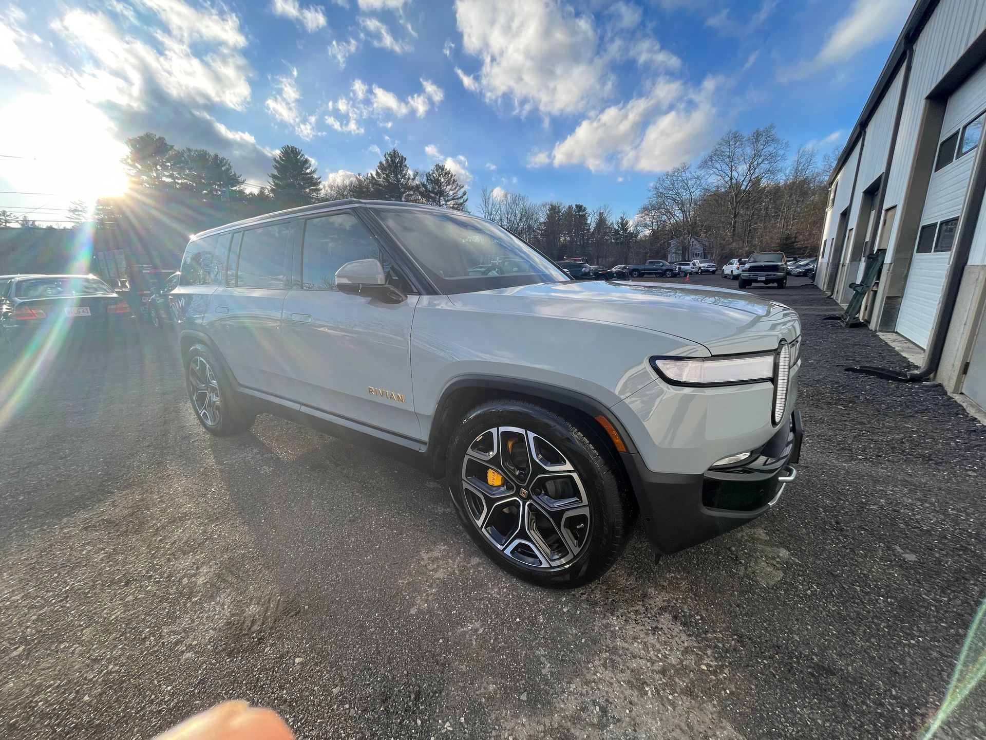 A white suv is parked in a parking lot in front of a building.