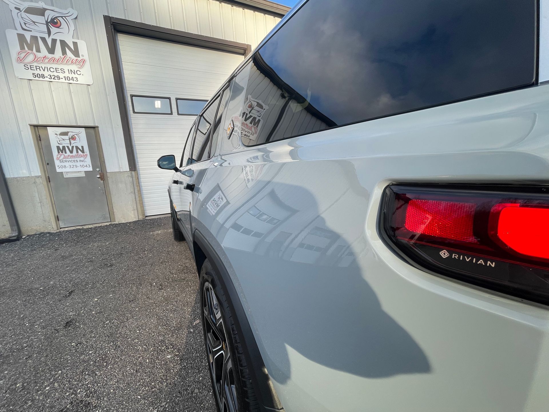 A white suv is parked in front of a garage.