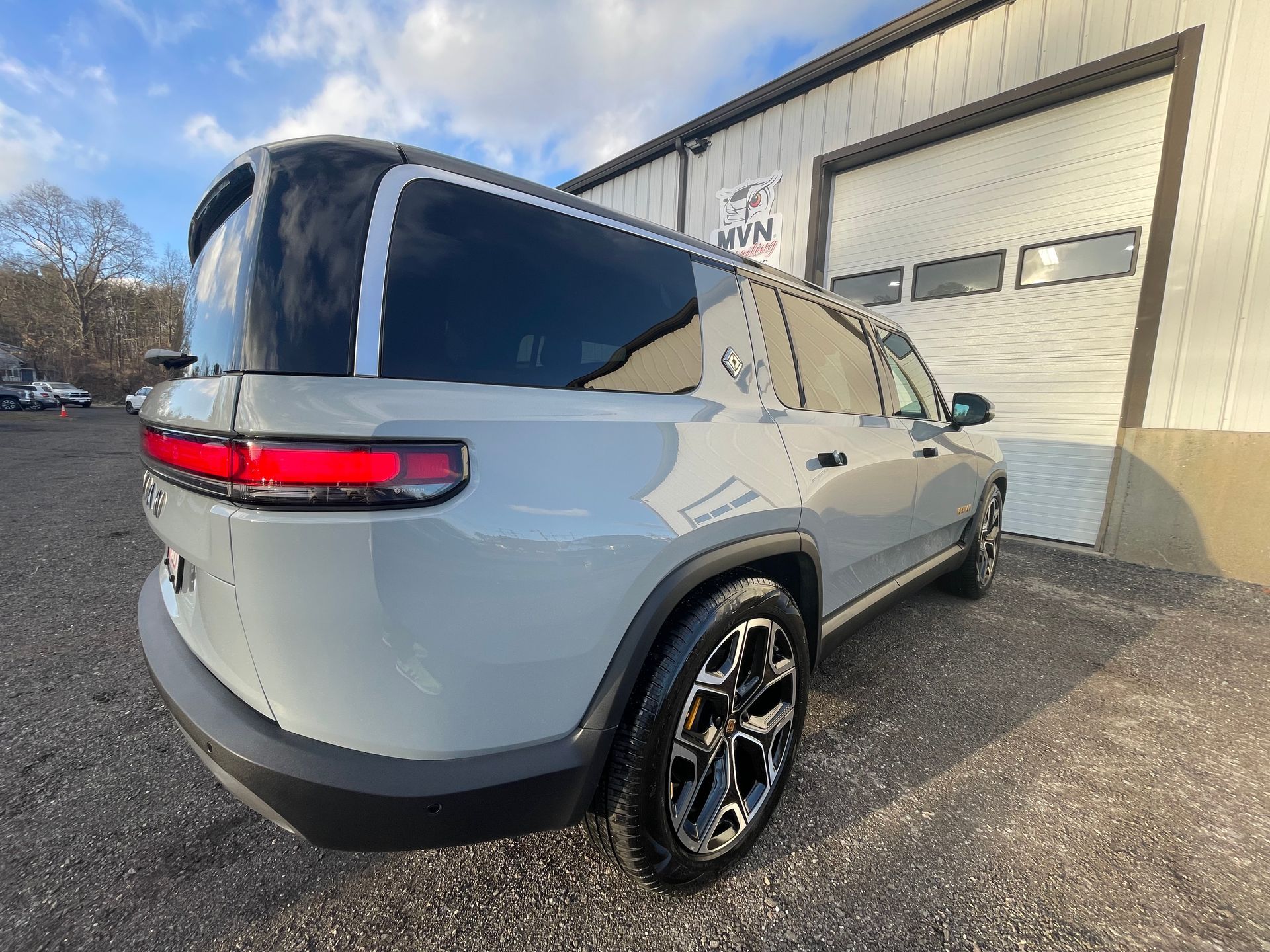 A silver suv is parked in front of a garage door.