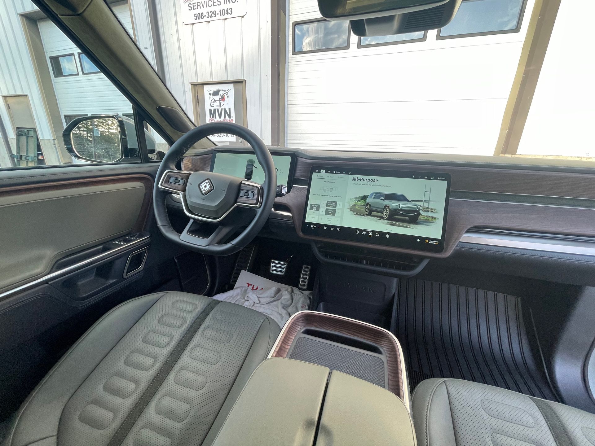 The interior of a car with a steering wheel and a tablet.