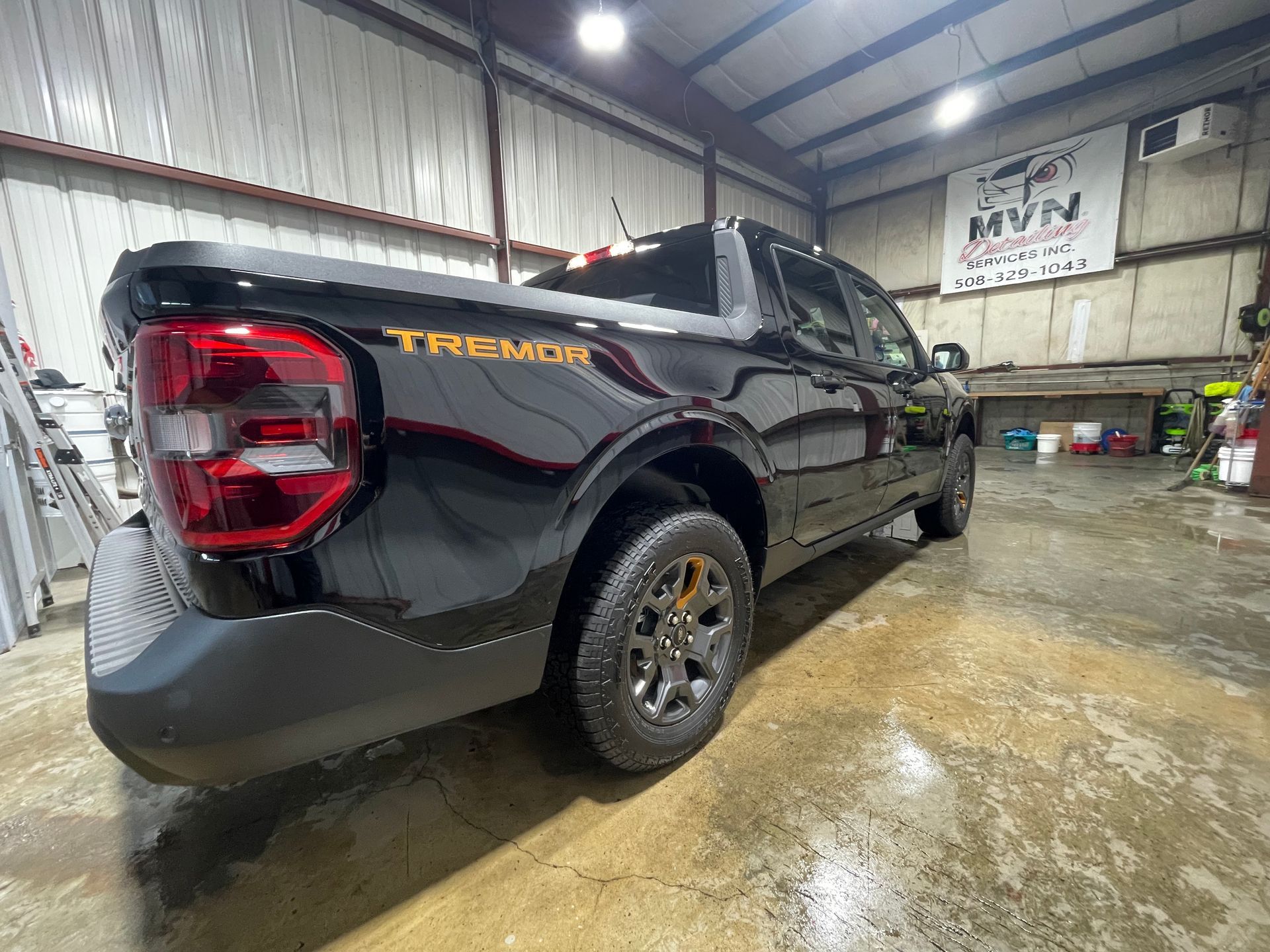 A black truck is parked in a garage.