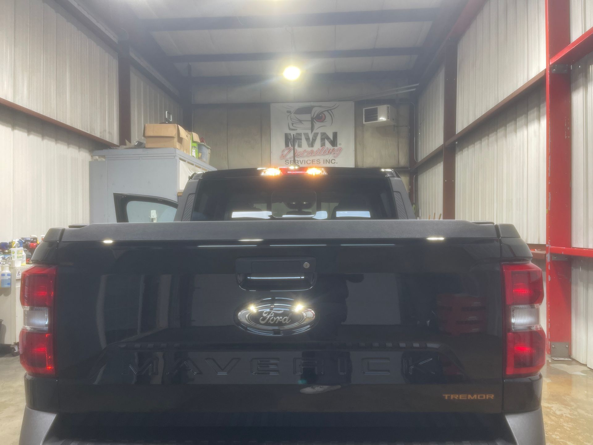A black pickup truck is parked in a garage.
