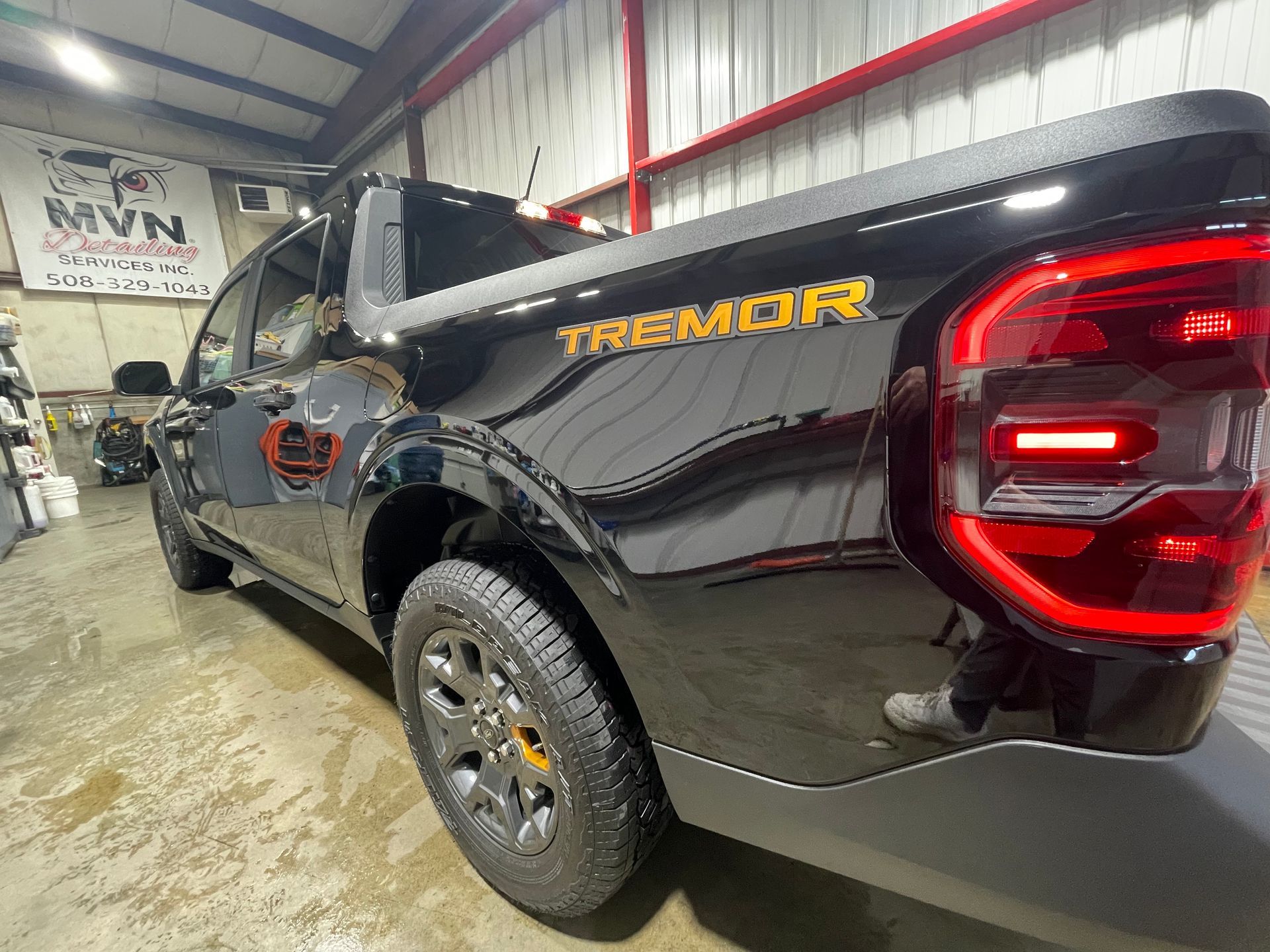 A black truck is parked in a garage.