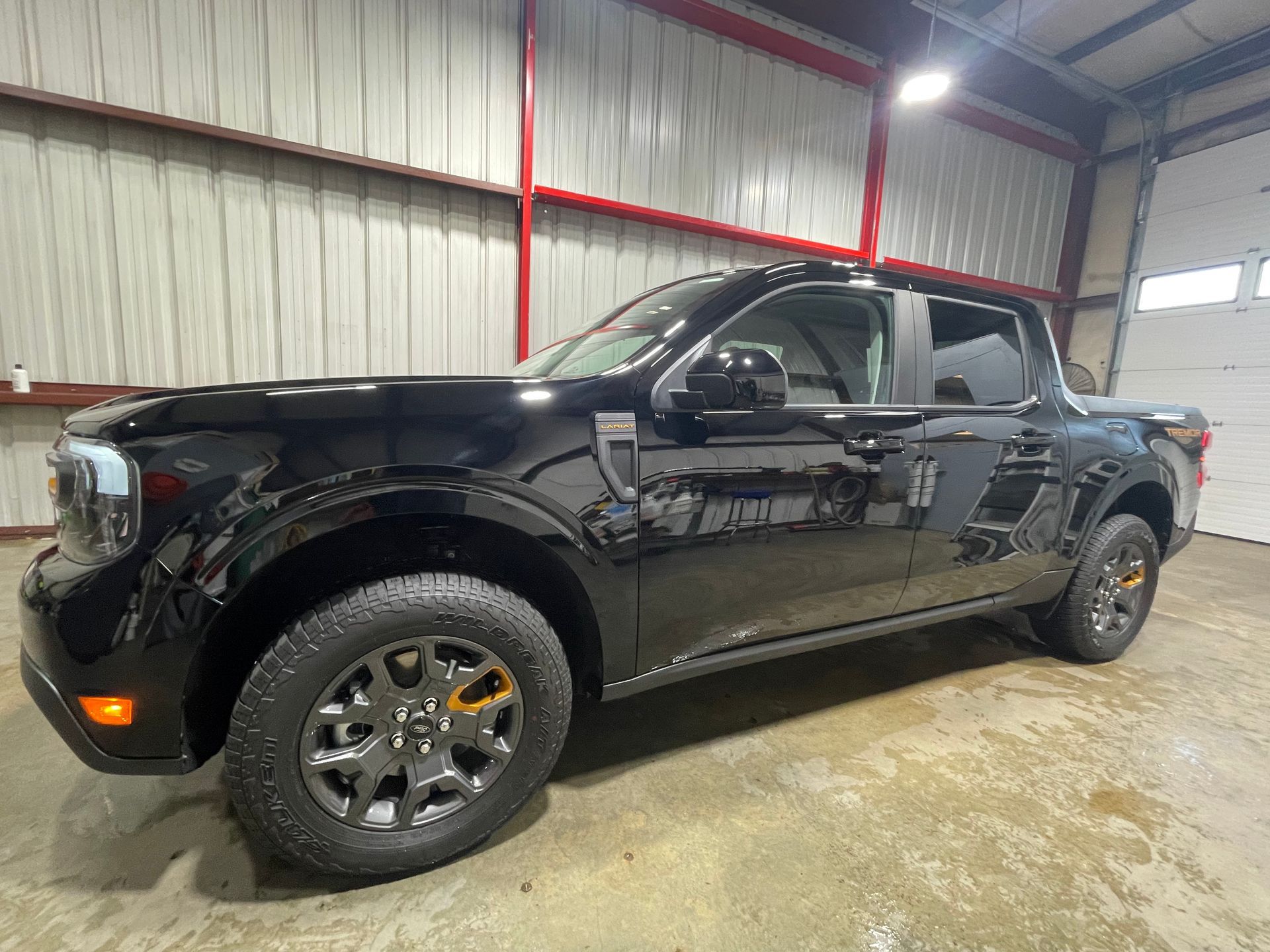 A black pickup truck is parked in a garage.