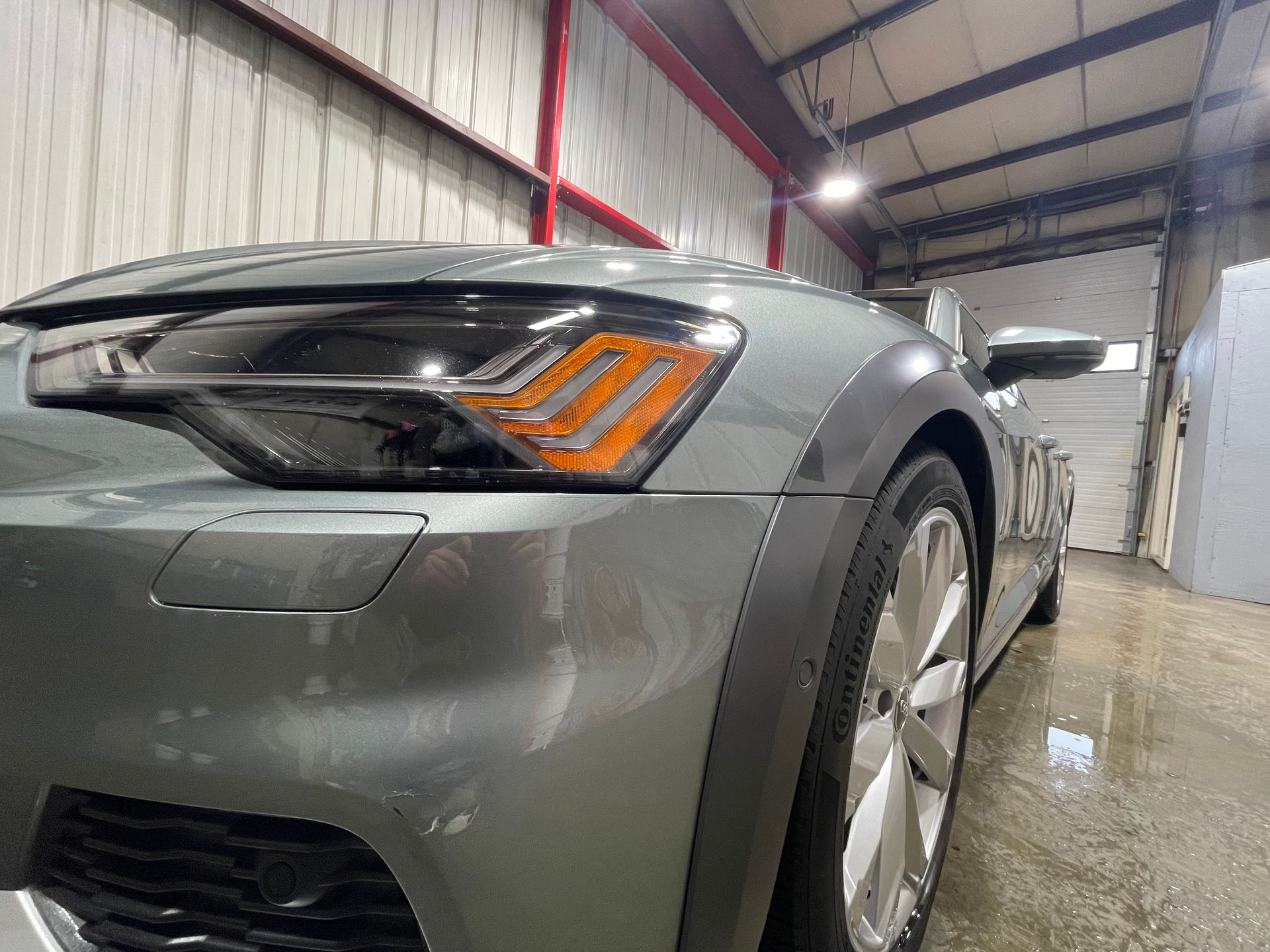 A close up of a car 's headlight in a garage.