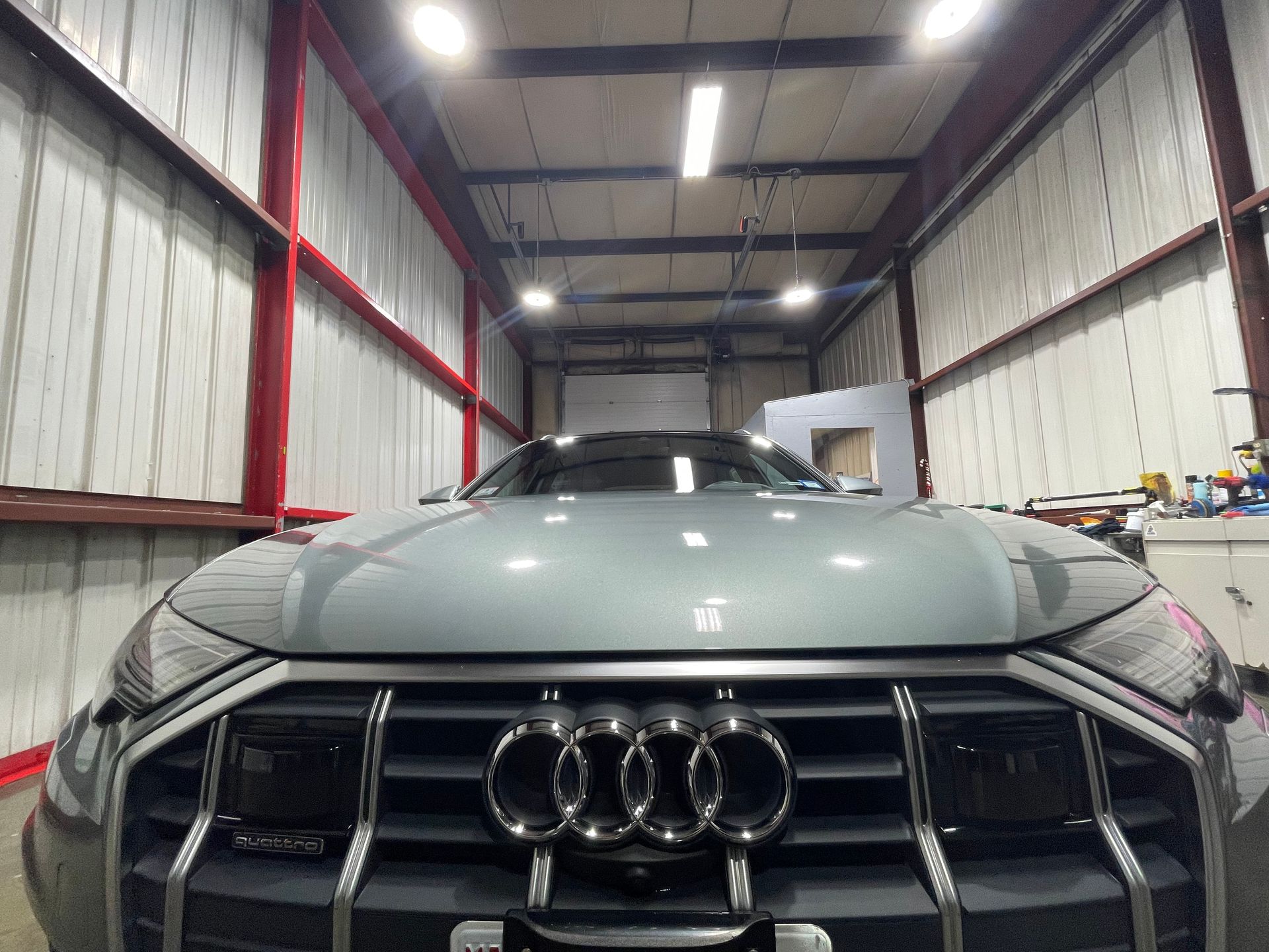 A grey audi q7 is parked in a garage.