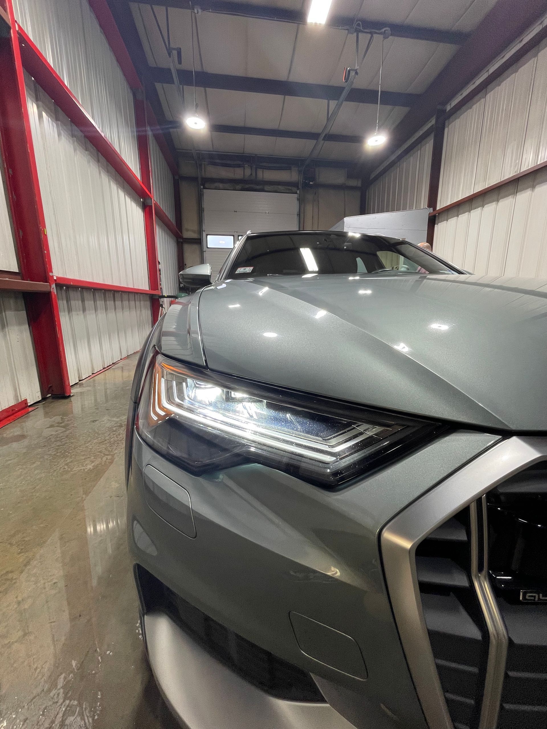 A gray car is parked in a garage.