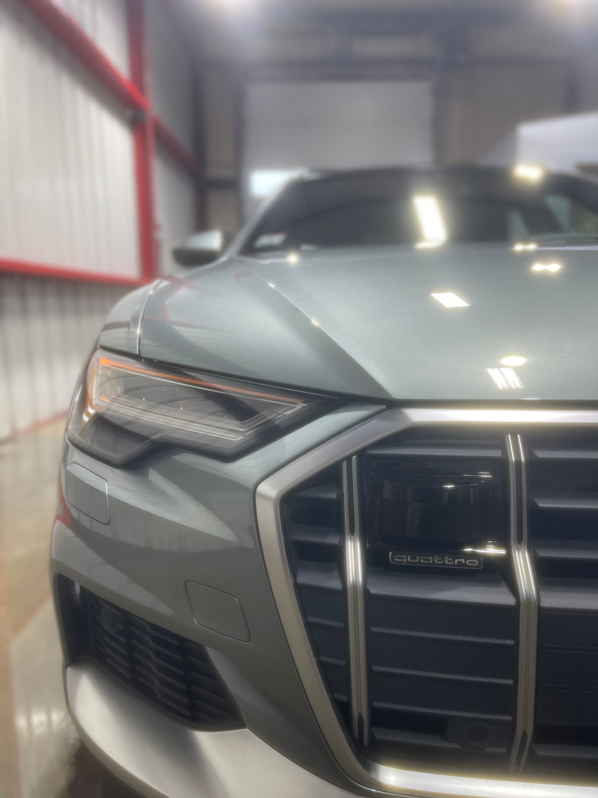 A close up of a car 's front end in a garage