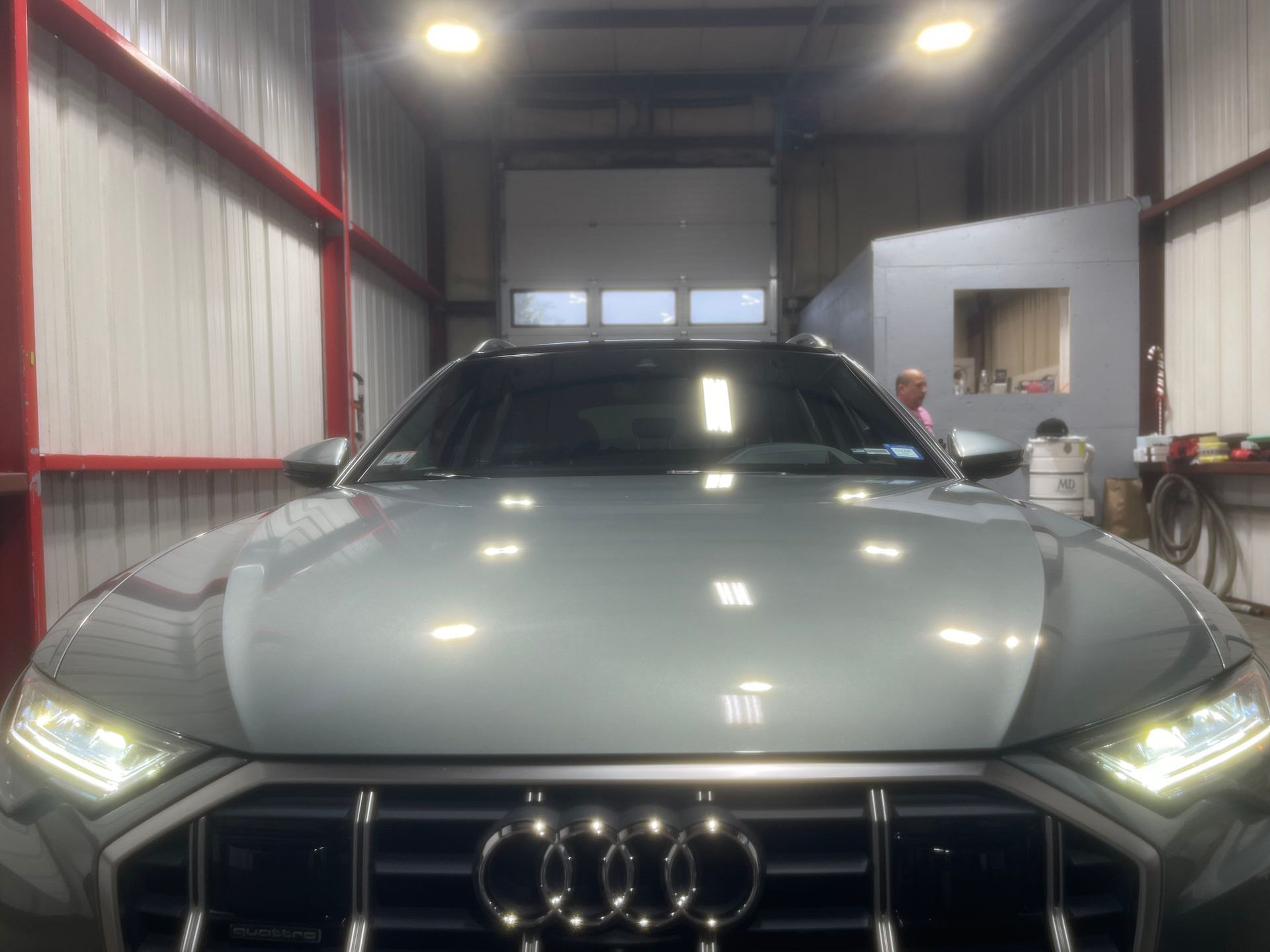 A silver audi q7 is parked in a garage.