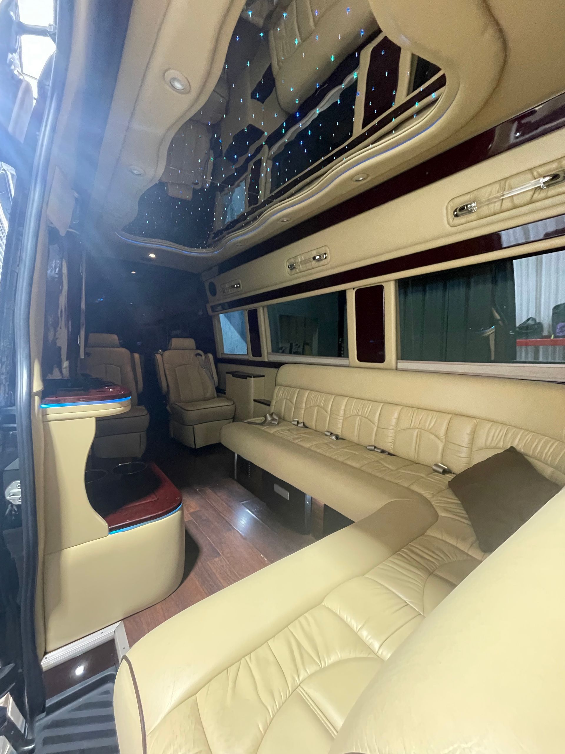 The inside of a van with a couch and chairs.