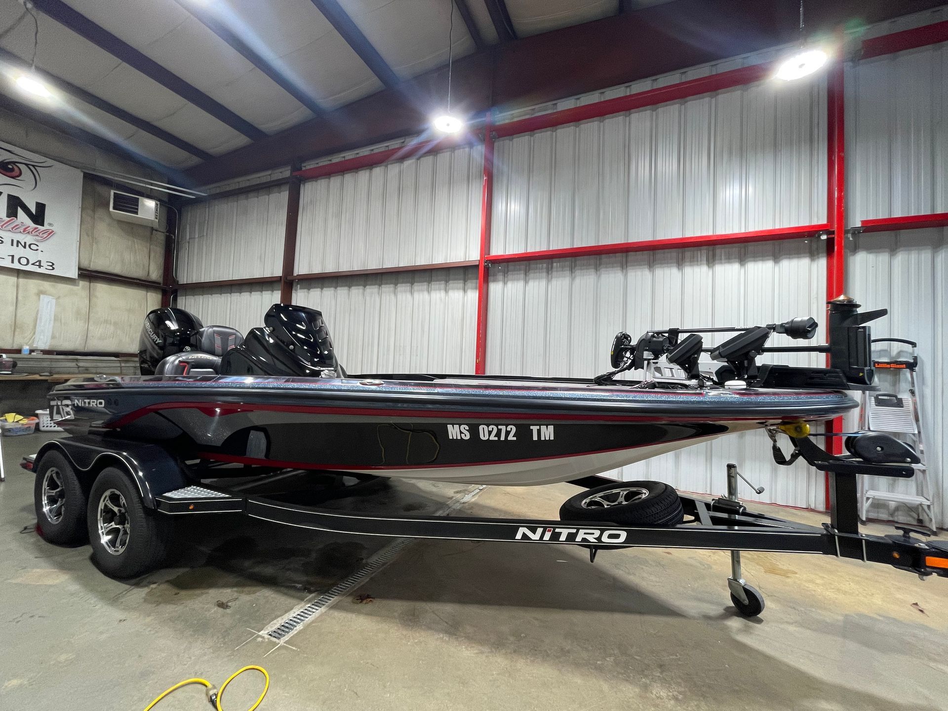 A fishing boat is parked in a warehouse.