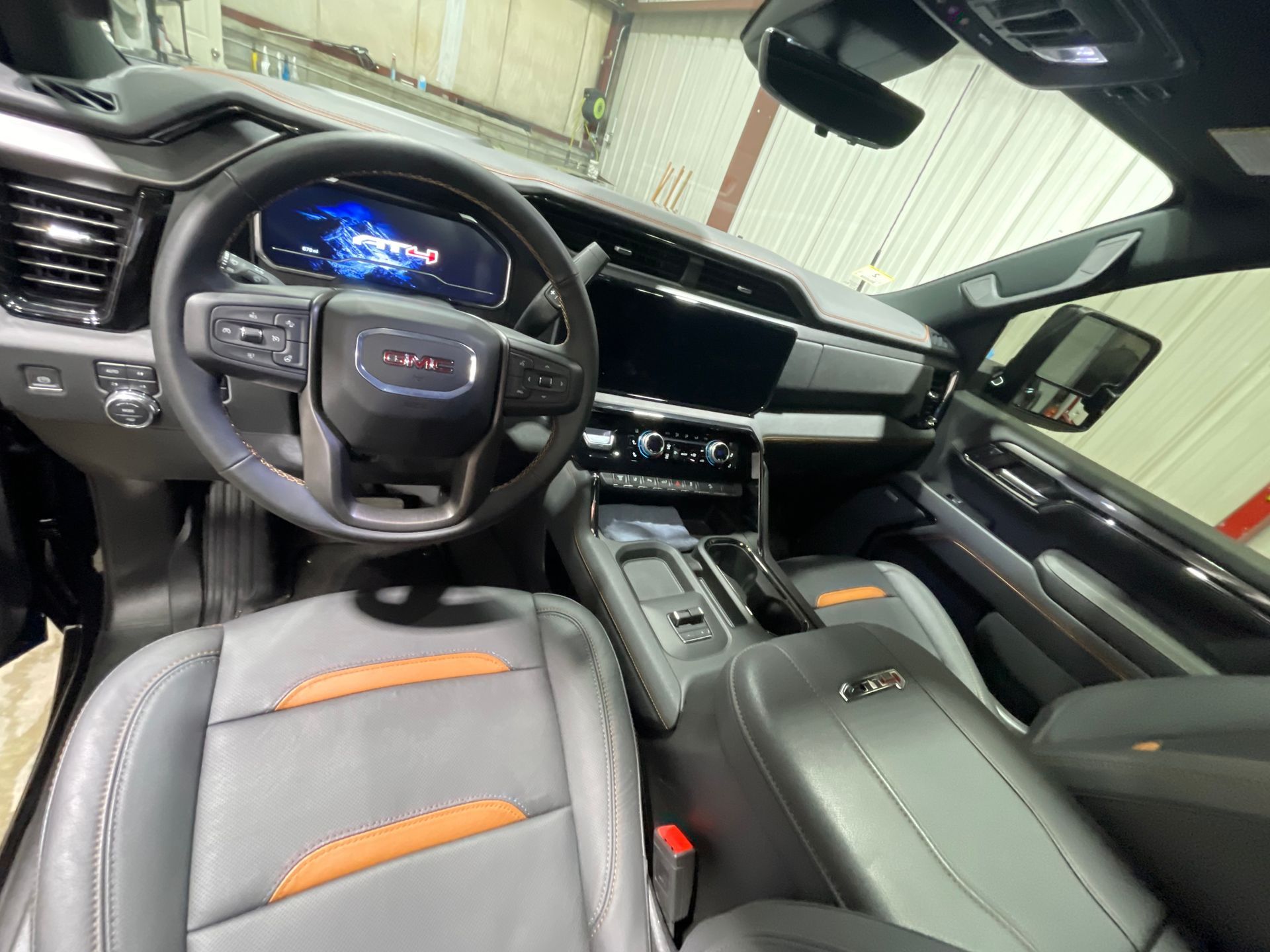 The interior of a gmc truck with a steering wheel and seats.