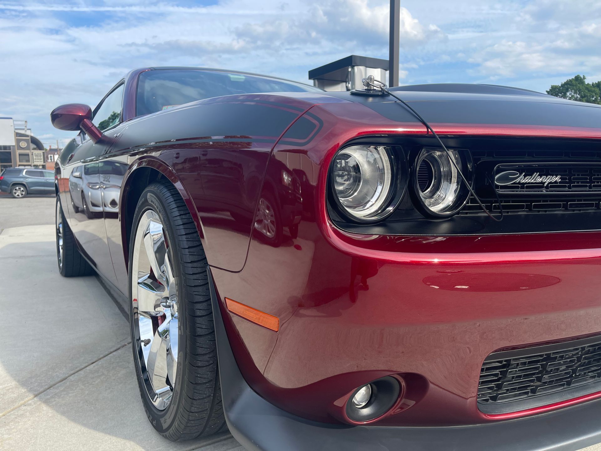 A red dodge challenger is parked in a parking lot.