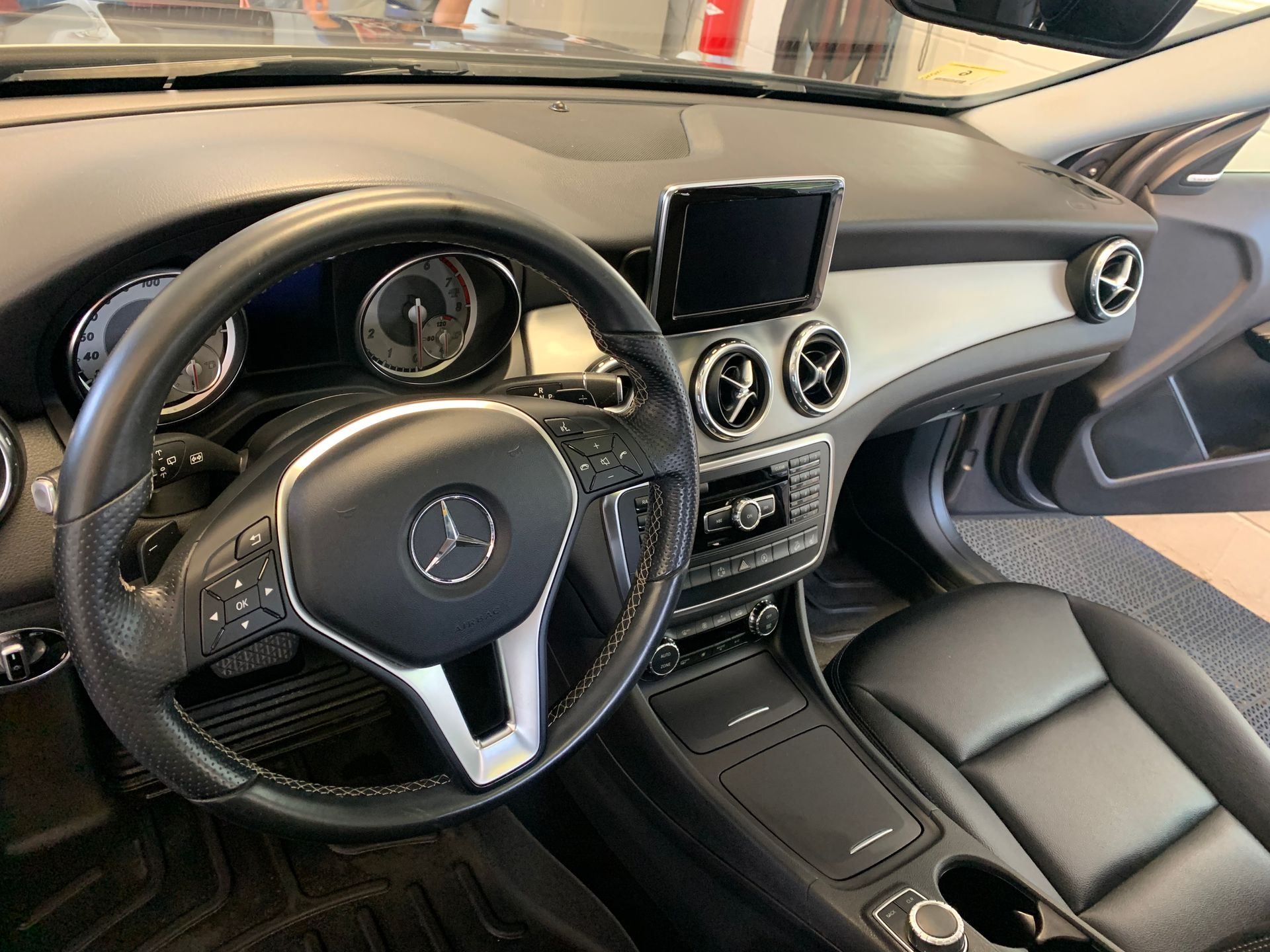 The interior of a mercedes benz car with a steering wheel and dashboard.