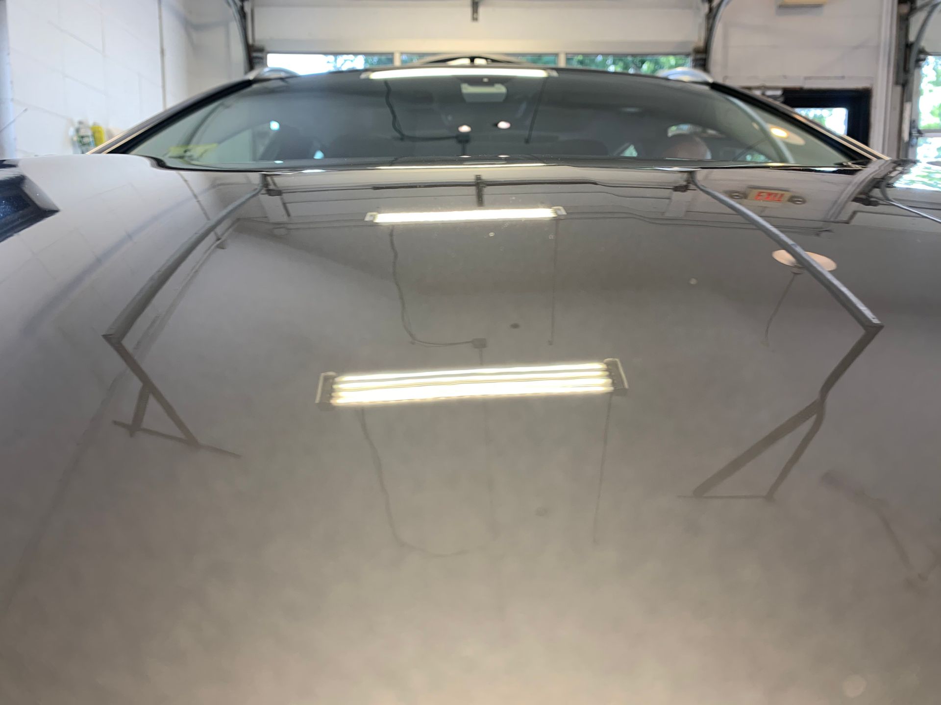 A car is parked in a garage with the hood open