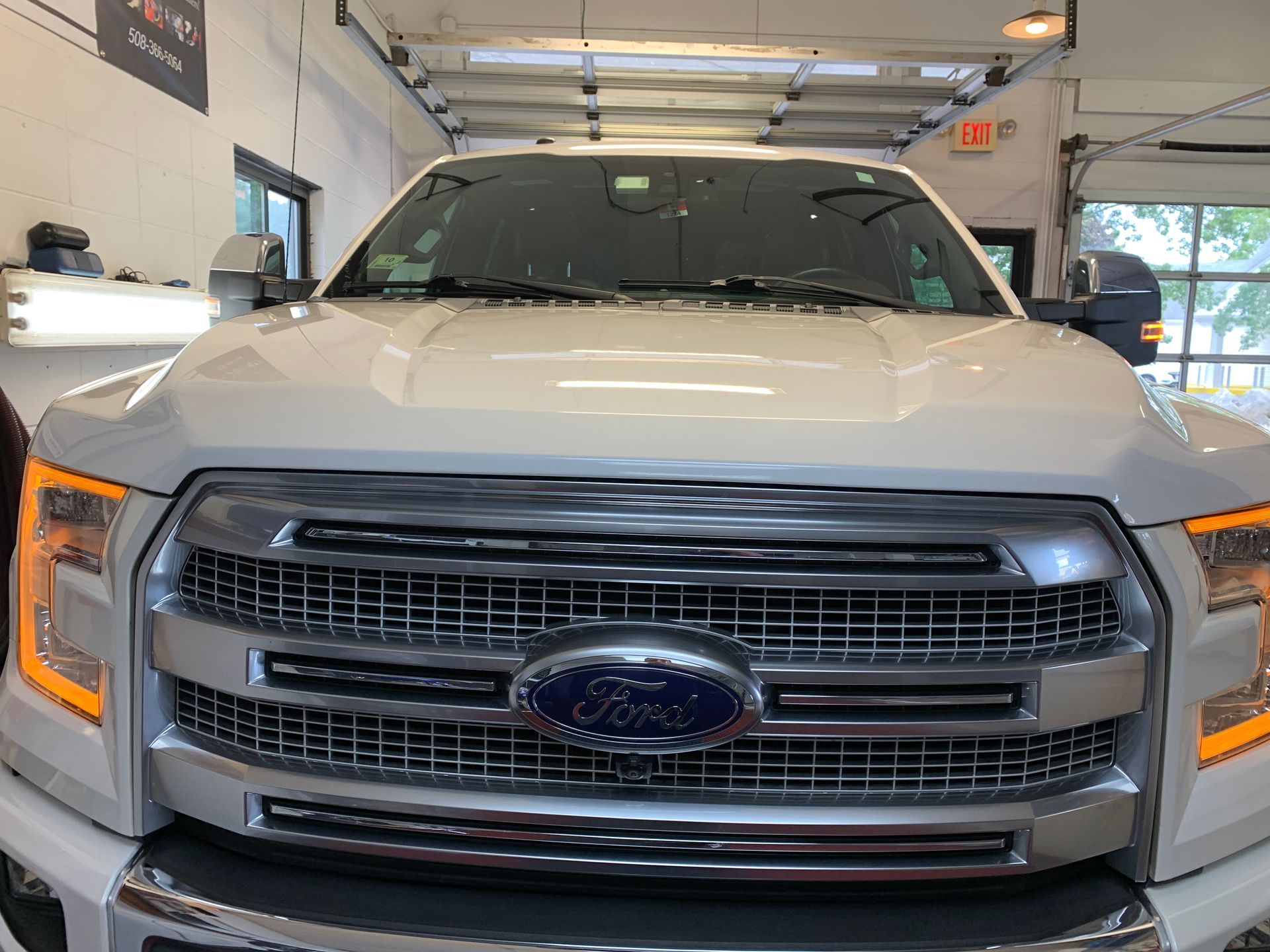 A white ford f150 truck is parked in a garage.