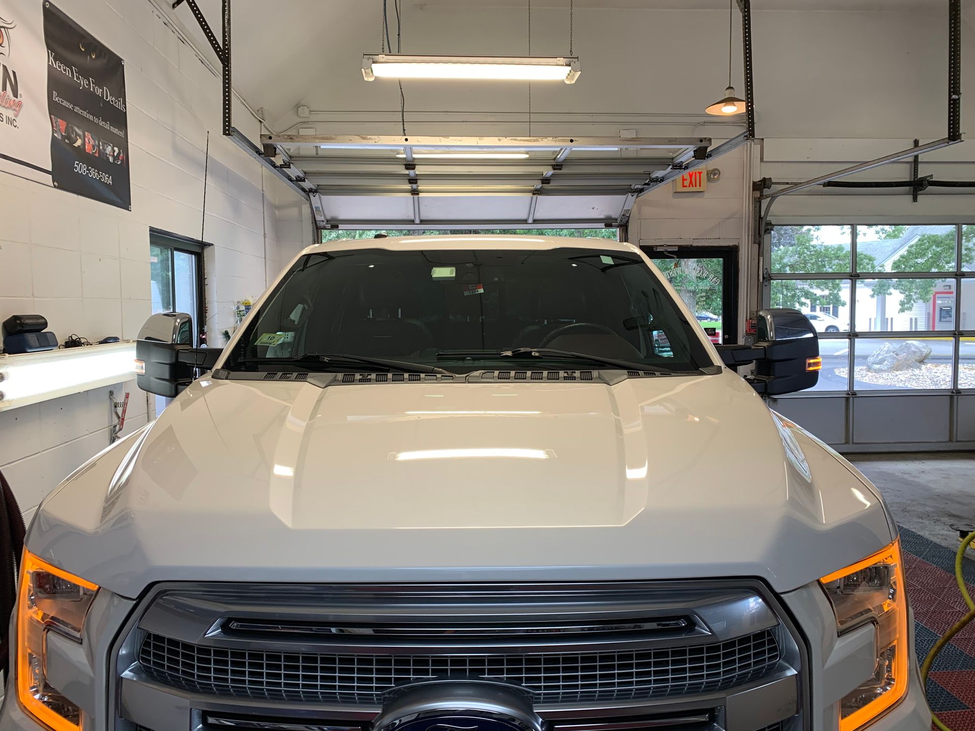 A white ford f150 is parked in a garage.