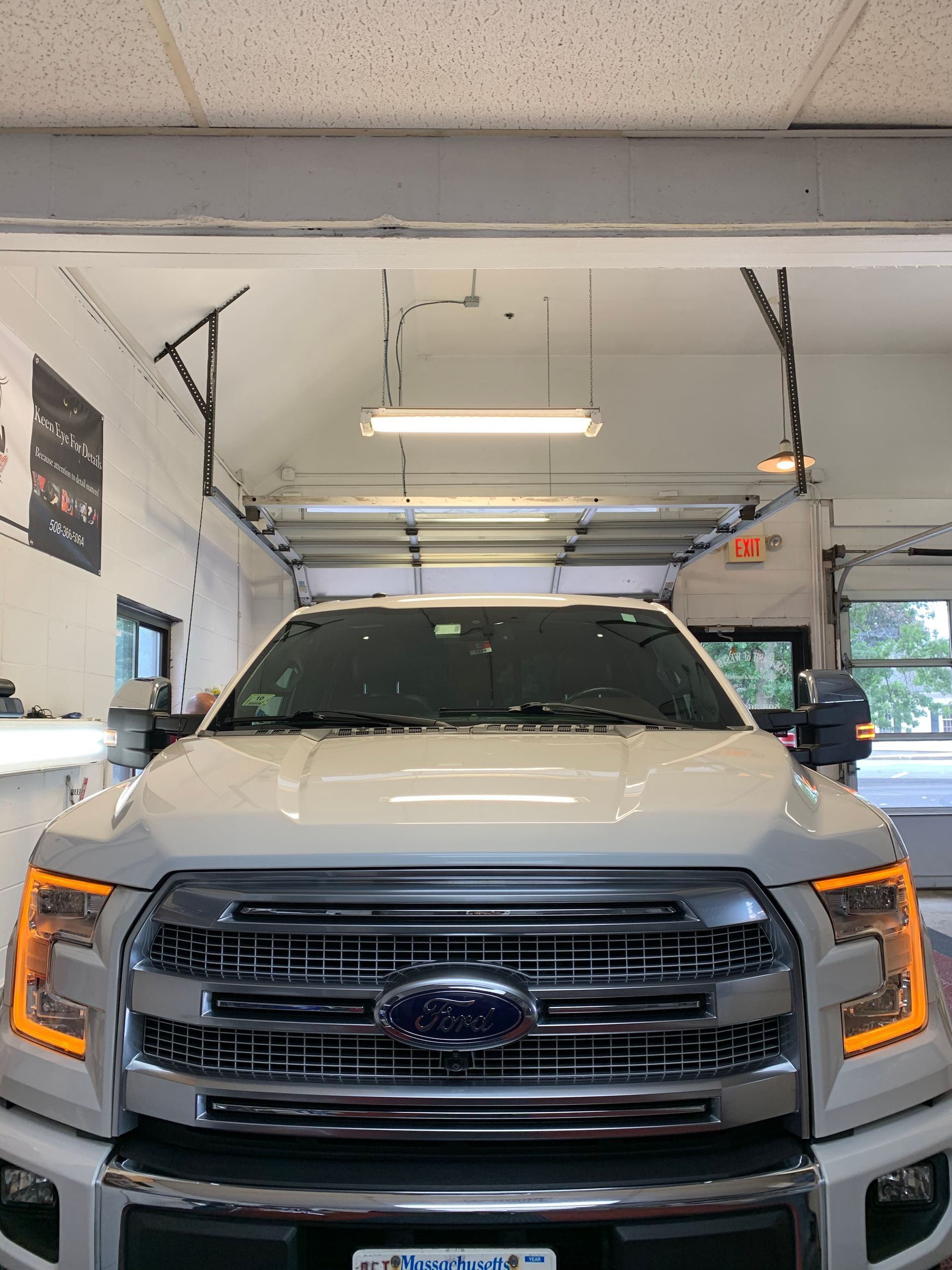 A white ford truck is parked in a garage.