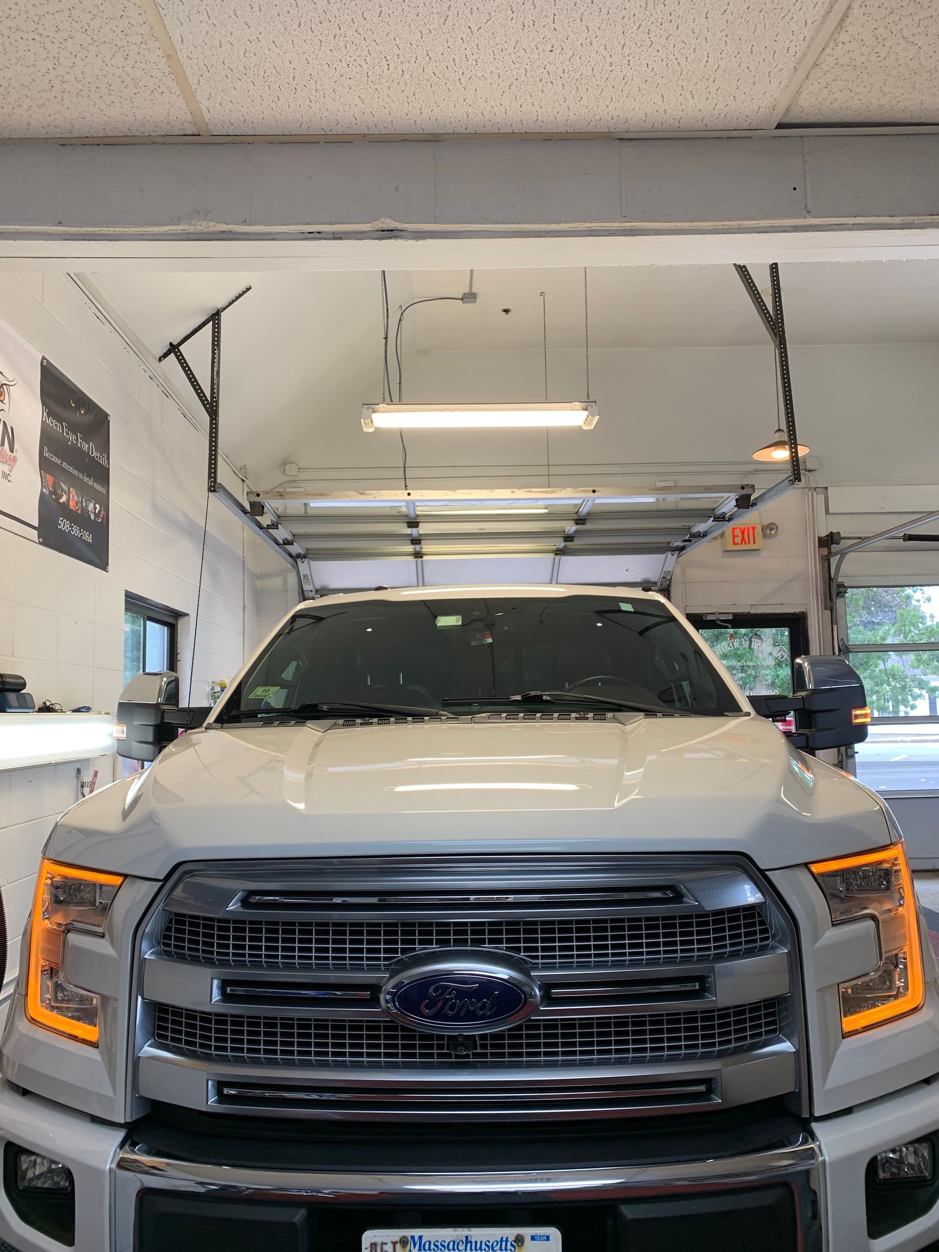 A white ford f150 is parked in a garage.