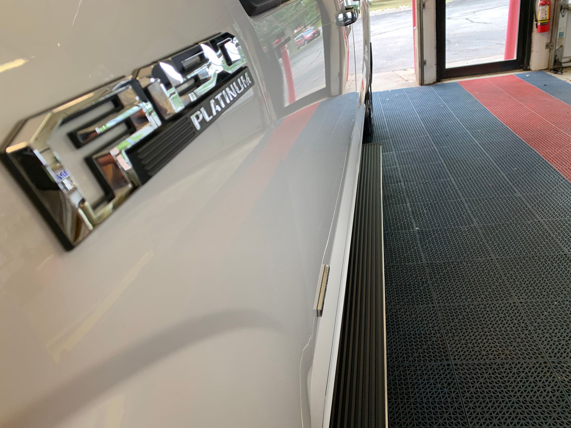 A white ford f150 platinum truck is parked in a garage.