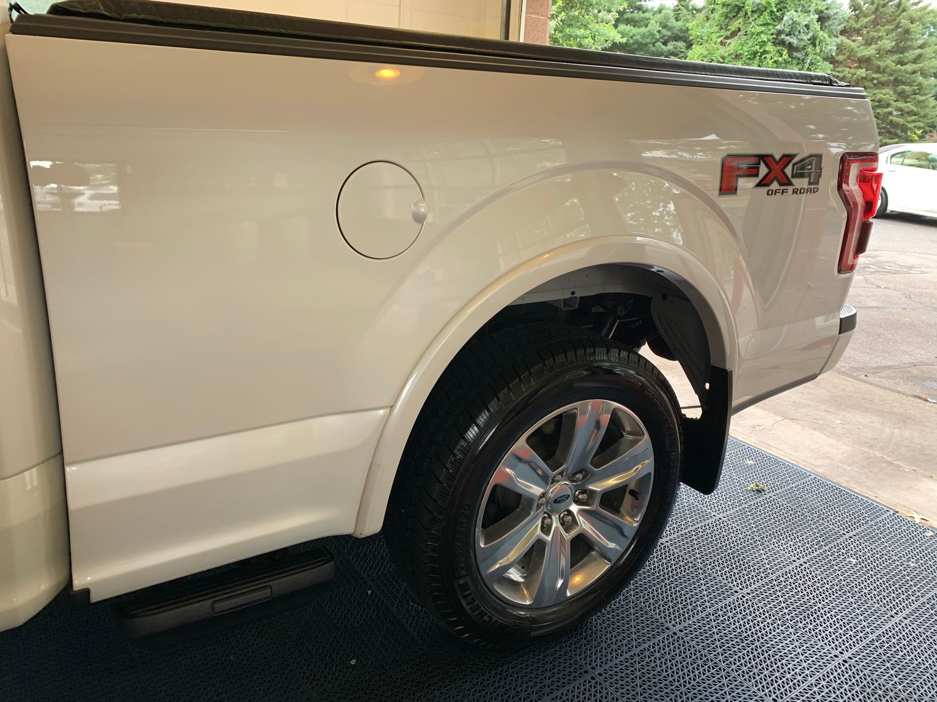 A white pickup truck is parked in a garage.