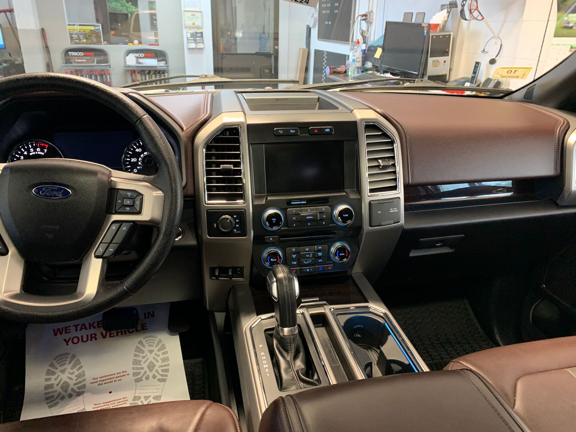 The interior of a ford f150 truck is shown in a garage.