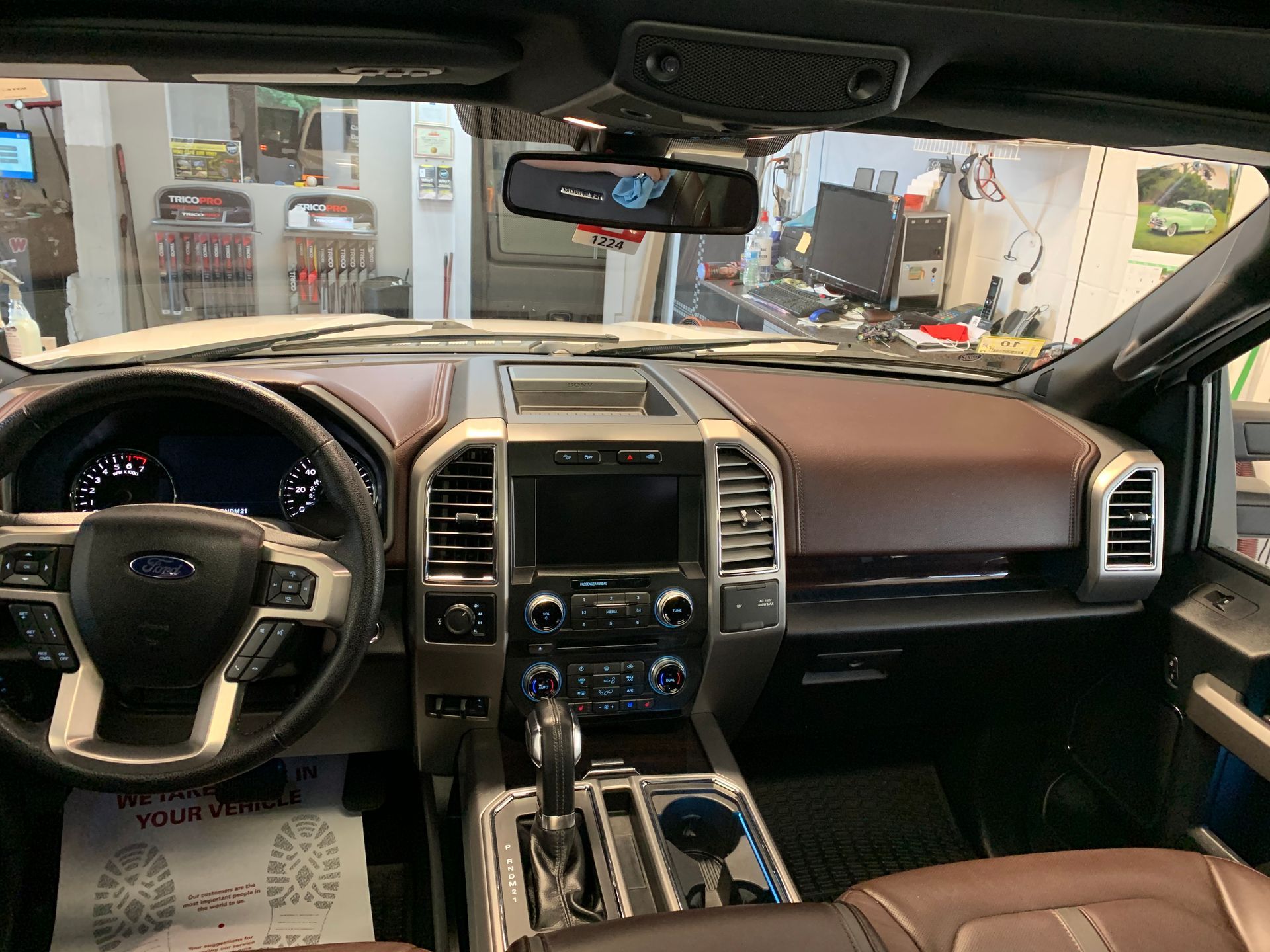 The interior of a ford truck is shown in a garage.