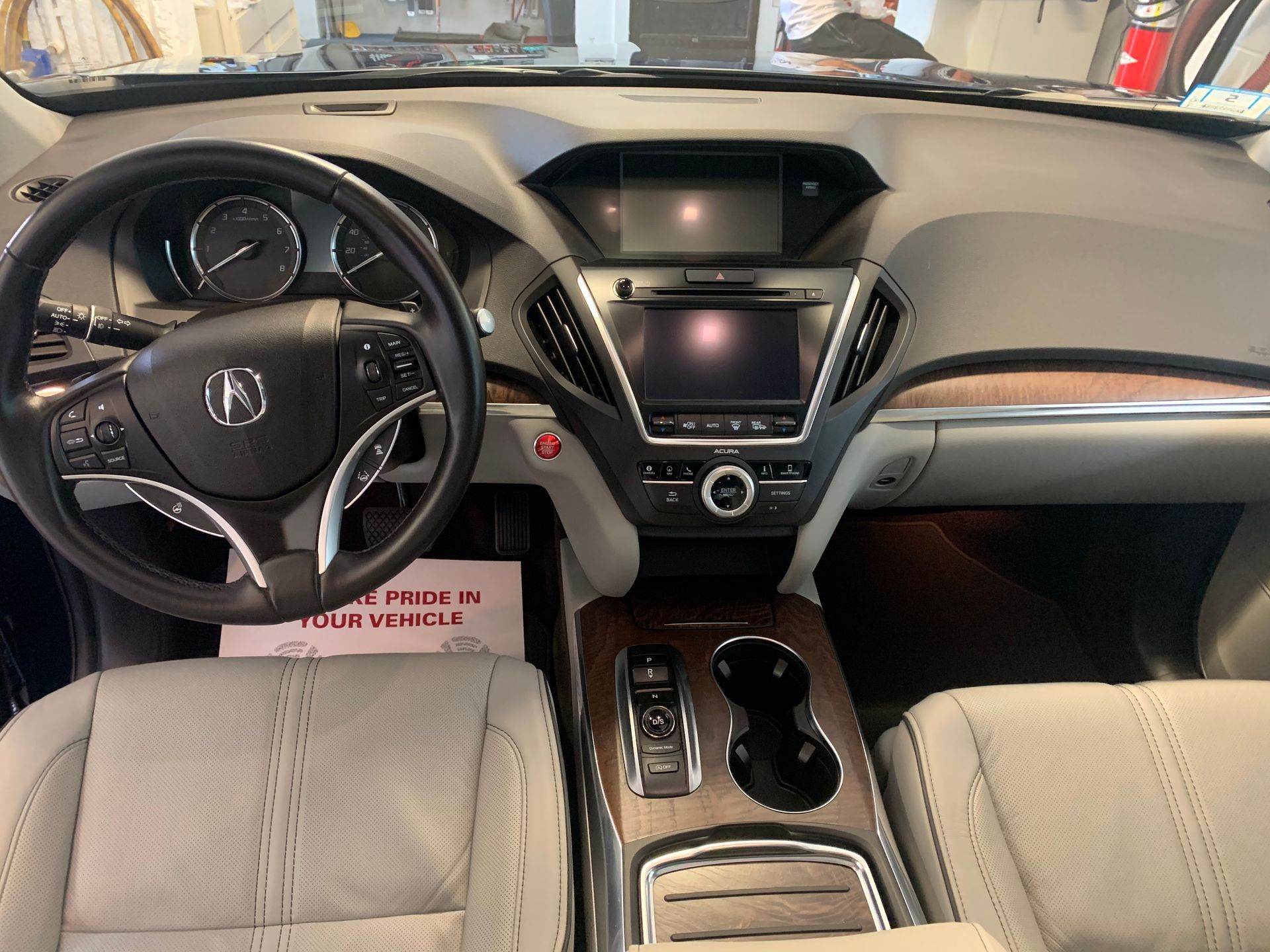 The interior of a car with a steering wheel and dashboard