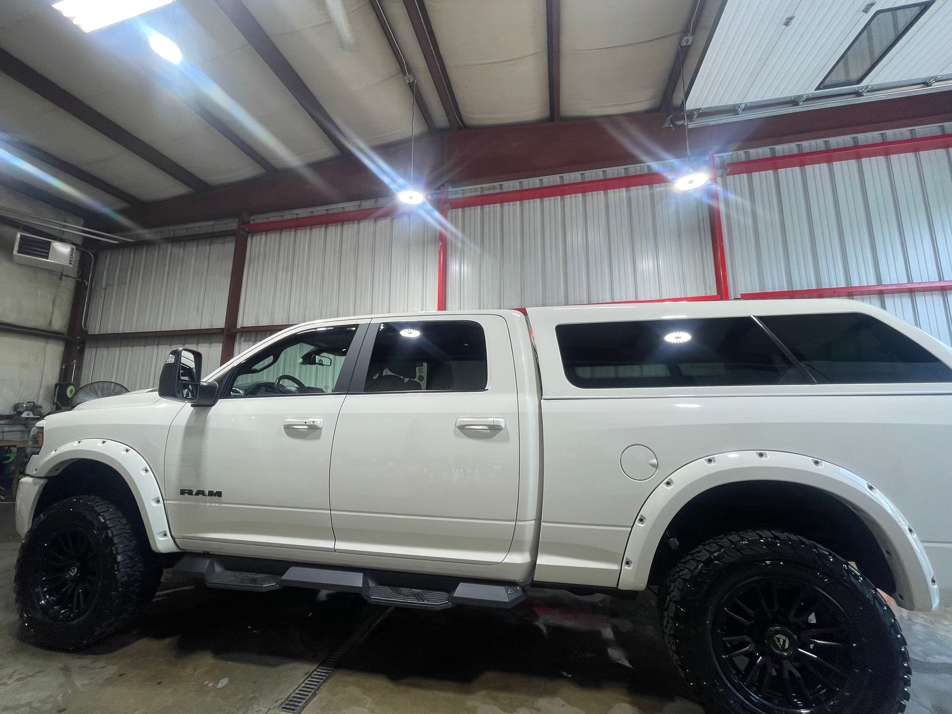 A white dodge ram truck is parked in a garage.