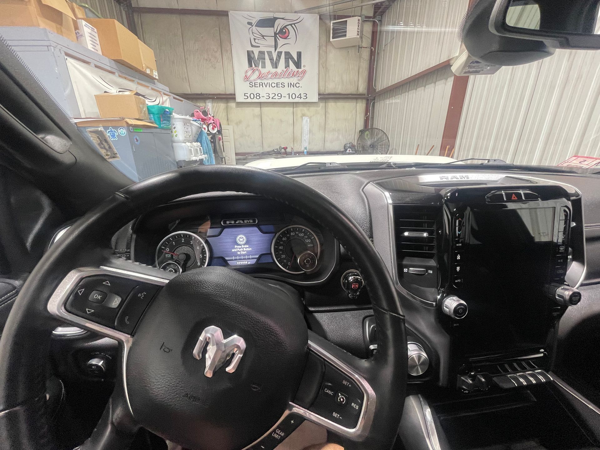A person is sitting in the driver 's seat of a dodge ram truck.