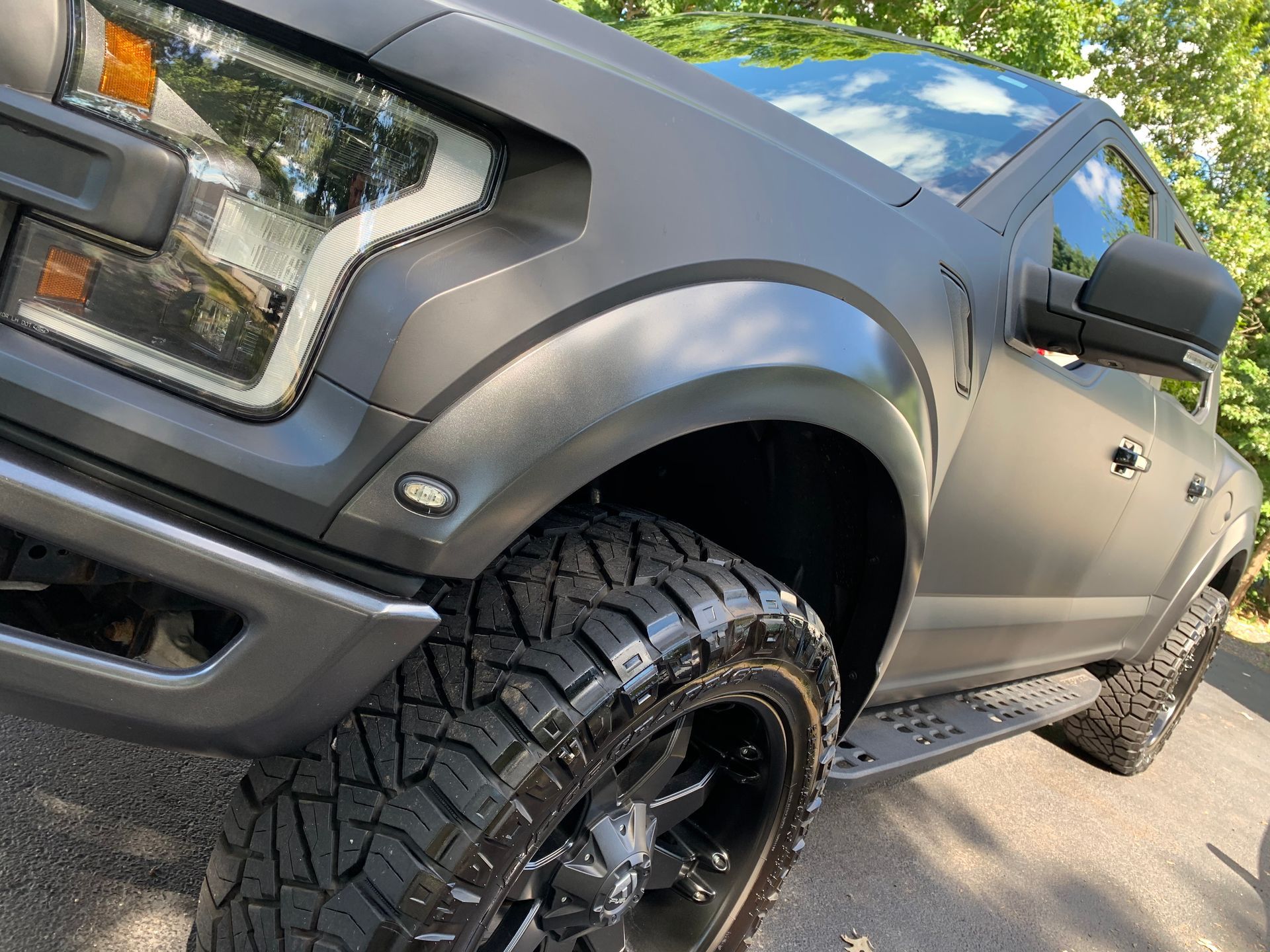 A black truck is parked on the side of the road.