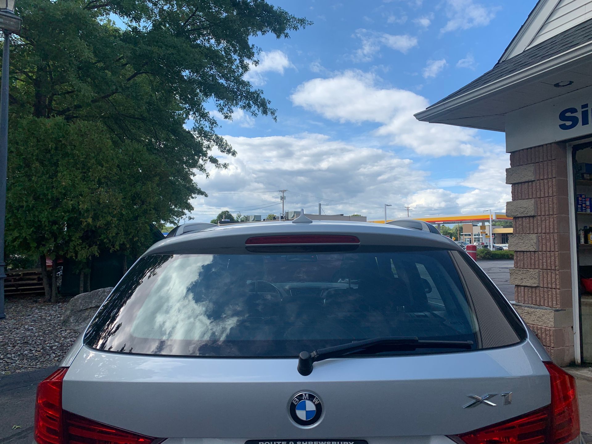 A silver bmw x1 is parked in front of a building.